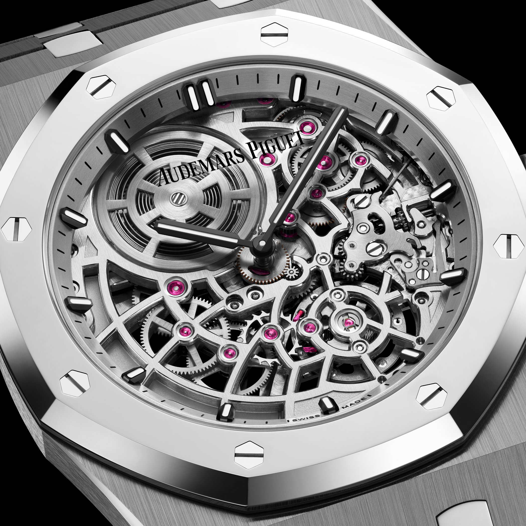 Macro of the Calibre 7124 seen through the dial, detailing the rhodium-toned bridges, the visible mainspring barrel at twelve, and the ruby jewels along the gear train