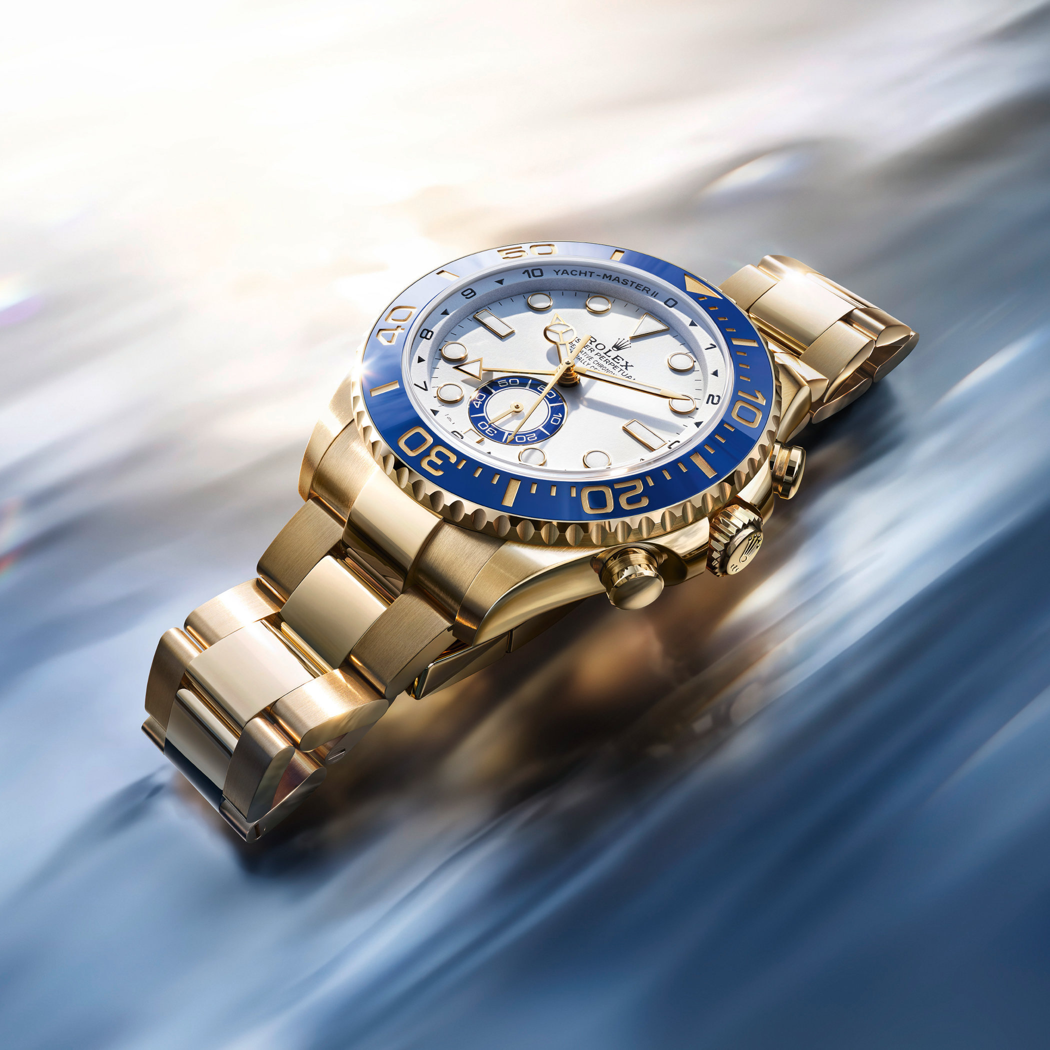 Three-quarter view of the yellow gold reference 126688, 44mm case and Oyster bracelet in 18-karat yellow gold with the same blue Cerachrom bezel and white dial