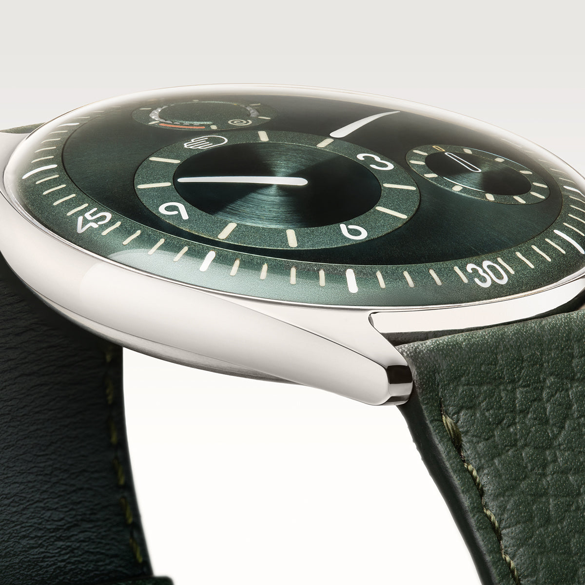 Ressence Type 11 Pine in profile, polished Grade 5 titanium pebble case, double-domed sapphire crystal flush with the case, Pine green leather strap and visible green sunburst dial