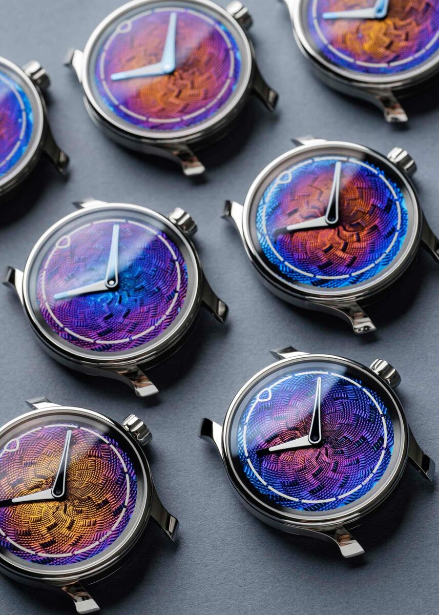 Eight 37.06 Lightning dials laid out together, each showing a different heat-colour gradient from the hand-torched process, illustrating how no two examples are identical