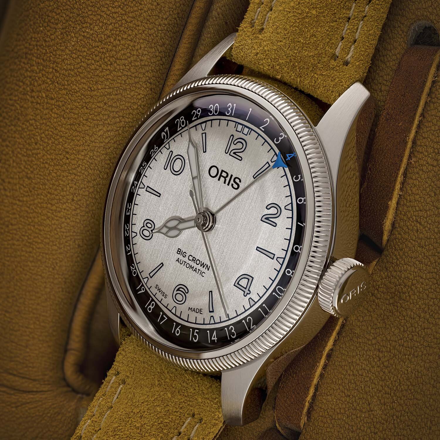 Three-quarter view of the Oris Big Crown showing the oversized screw-in crown, knurled bezel and cathedral hands on the brown double-stitched suede strap
