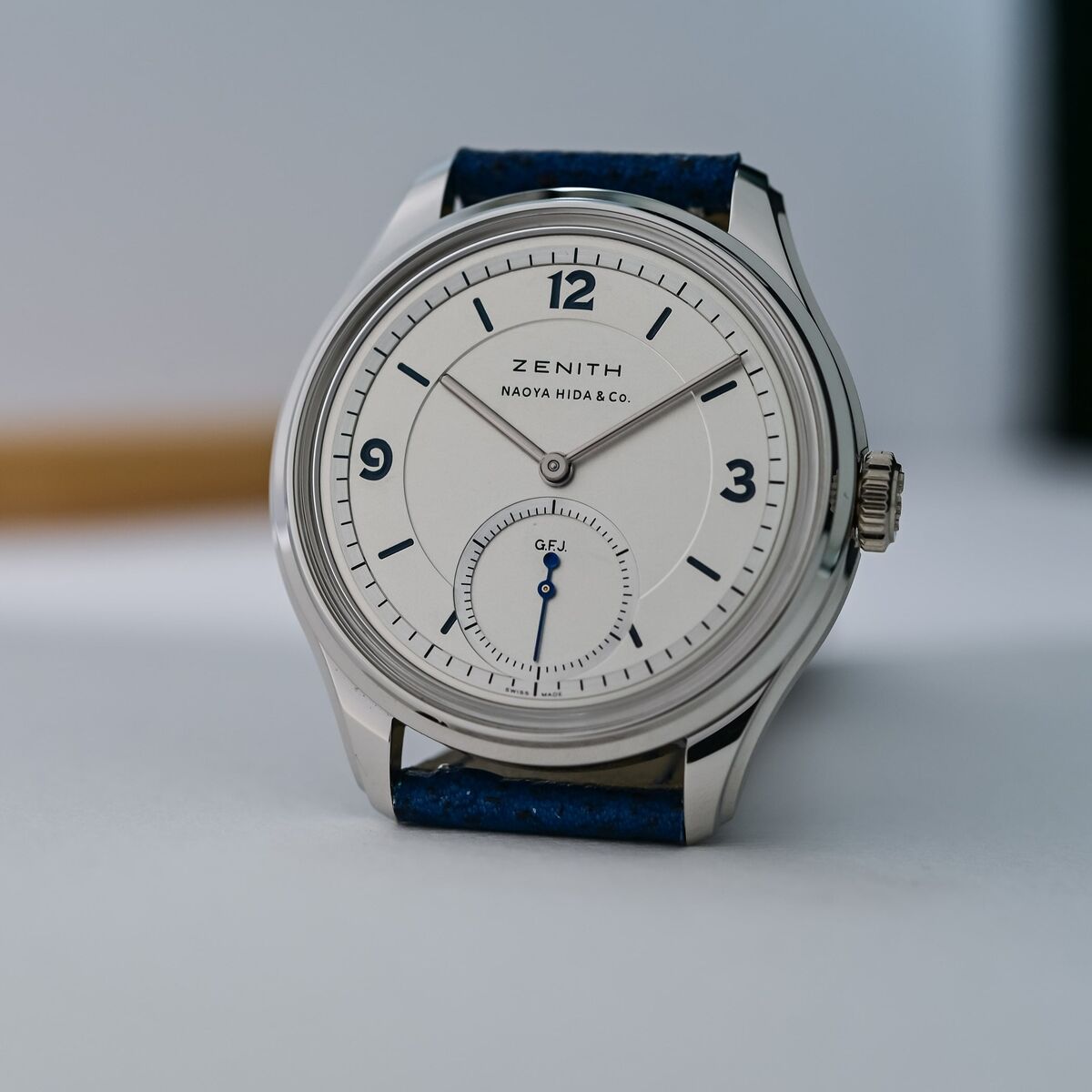 The Zenith G.F.J. Double Signed standing upright, showing the platinum case, stepped lugs, slim polished bezel and the solid silver dial with blue-lacquered numerals and small seconds