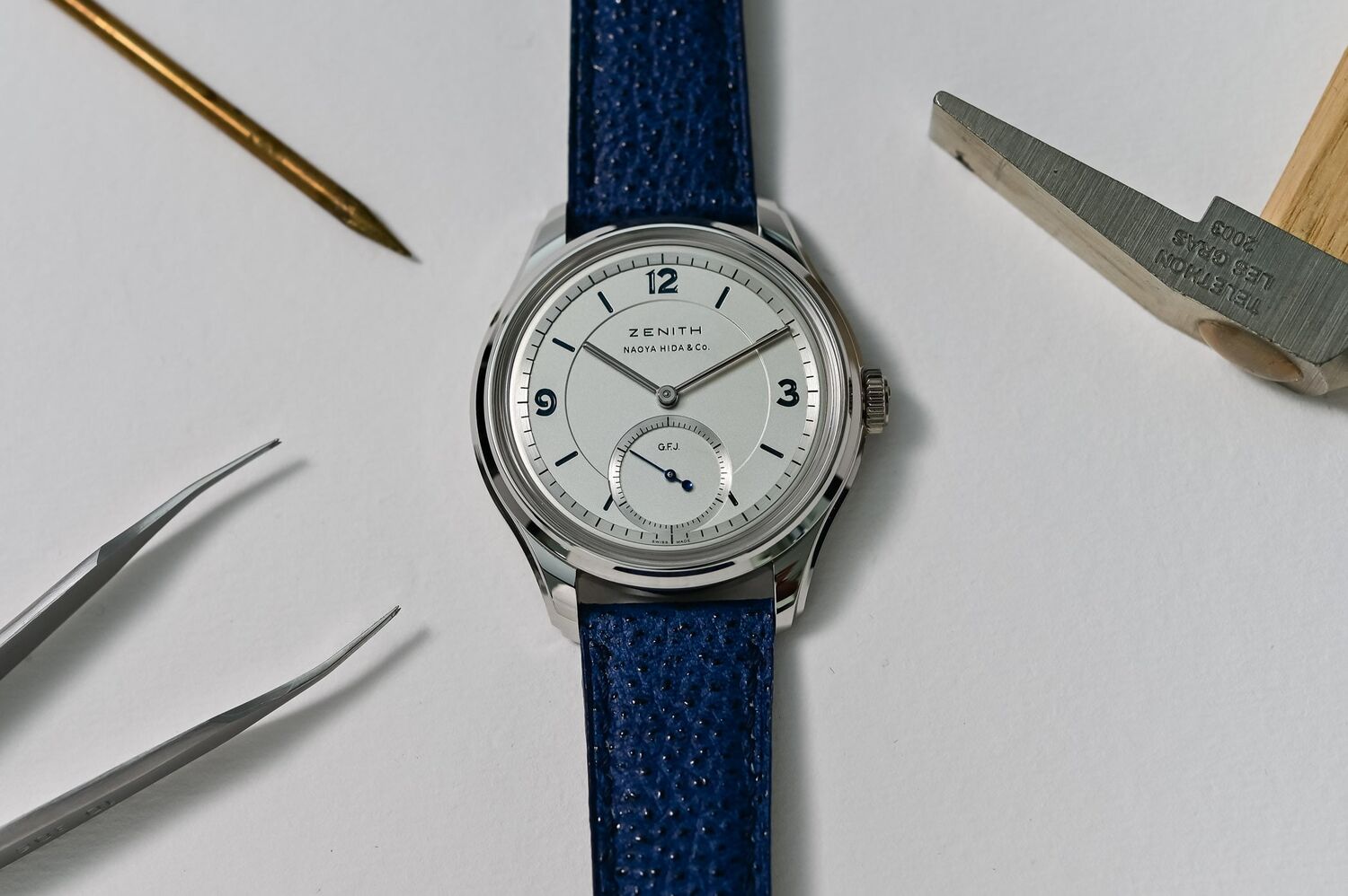 Zenith G.F.J. Calibre 135 Double Signed with Naoya Hida and Co. photographed flat among watchmaker's tools, platinum case with a solid silver dial carrying the ZENITH and NAOYA HIDA and Co. double signature, small seconds at six marked G.F.J., on a blue Kaihara denim strap