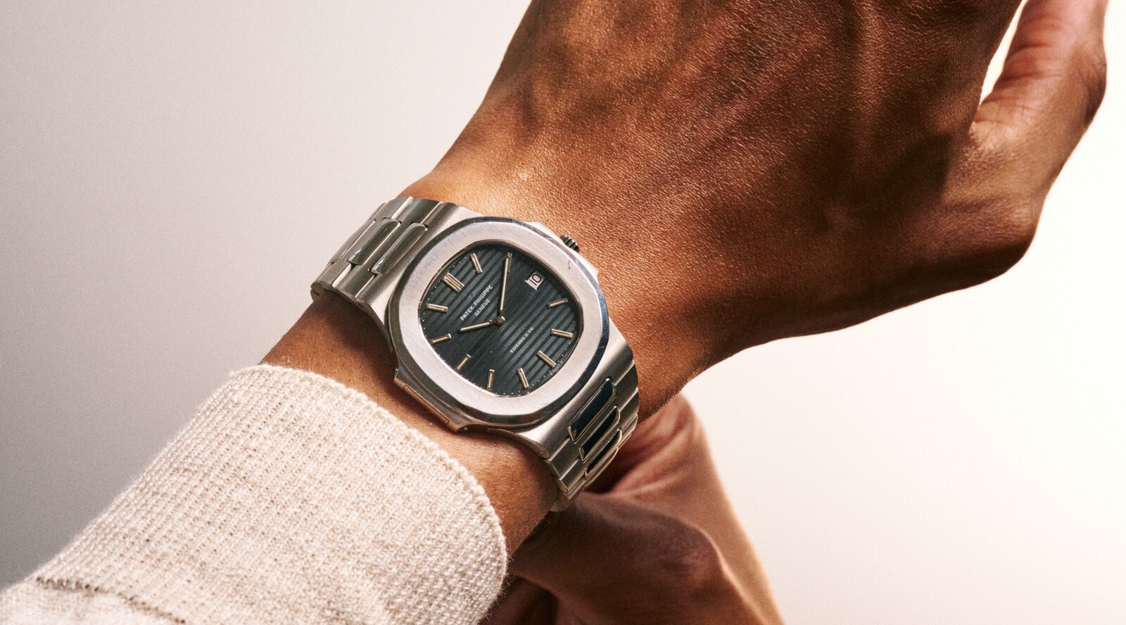 Patek Philippe Nautilus reference 3700/11 'Jumbo' with Tiffany & Co.-signed blue-black embossed dial on the wrist, part of the nine-reference Nautilus anniversary run, lot 26 of the sale