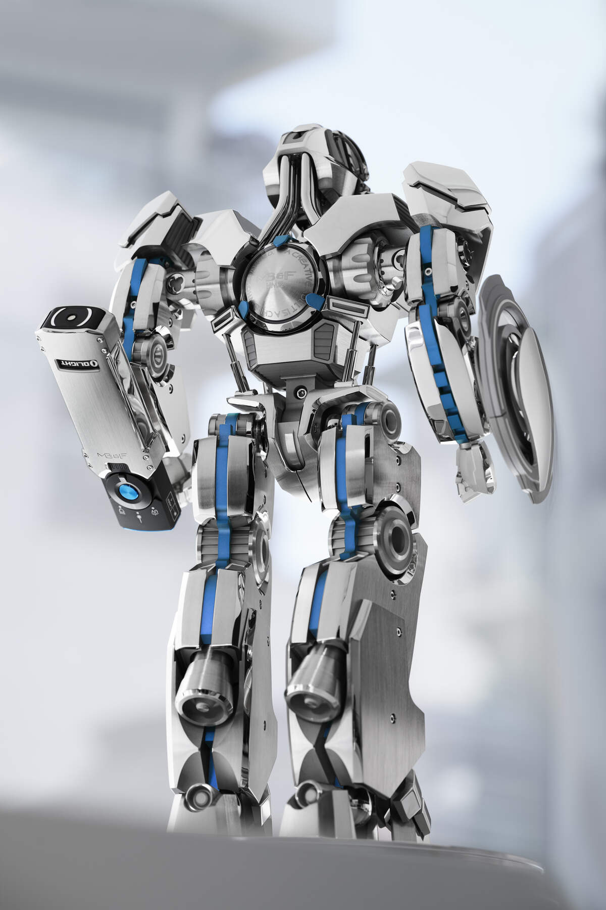 The Guardian robot by L'Épée 1839, 38.2cm tall in polished steel with blue accents, seen from behind with the UV torch arm and shield arm, MB&F engraving on the back plate