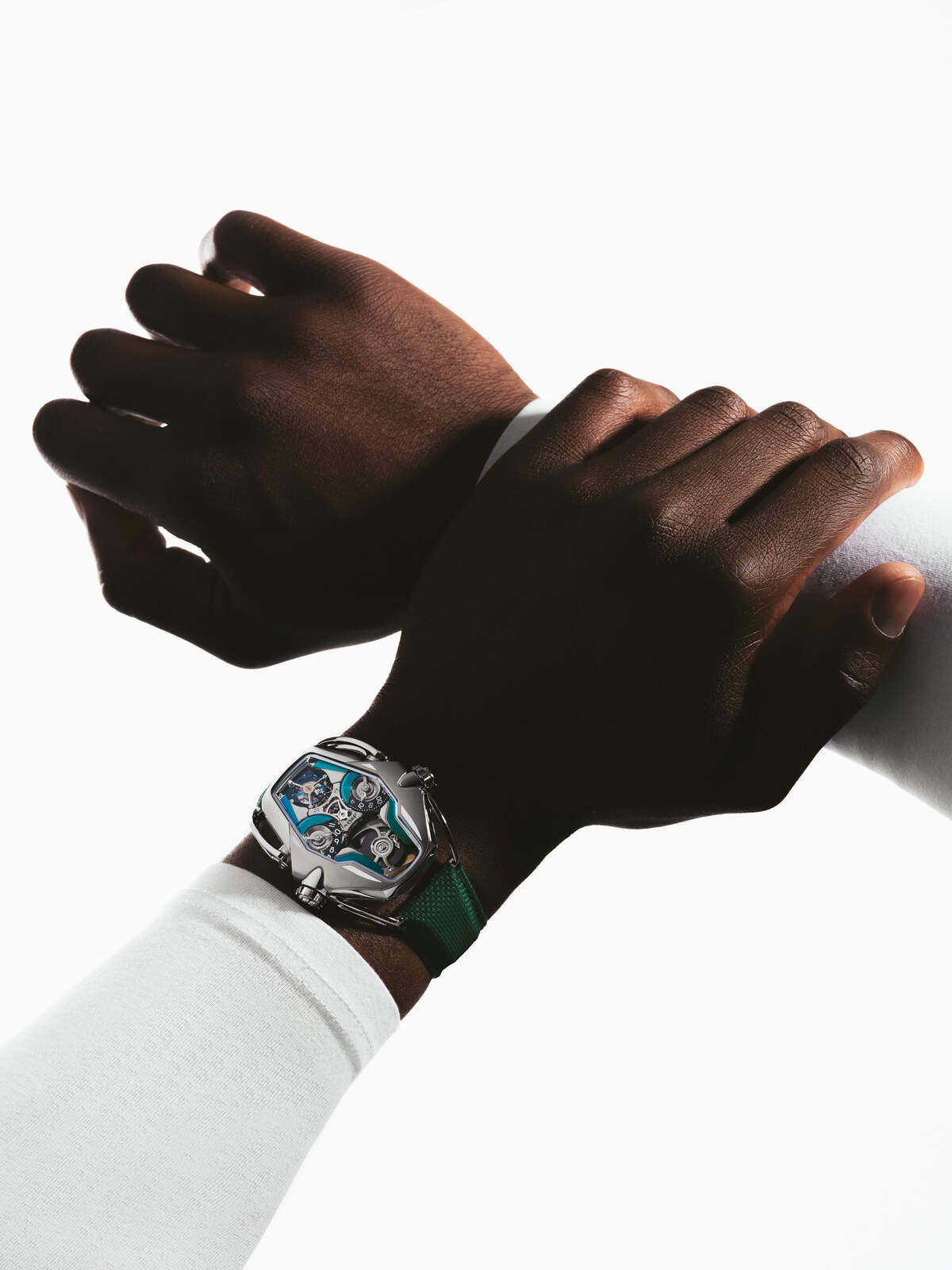 MB&F HM12 green edition on the wrist, titanium case with green and teal accents on a green textile strap