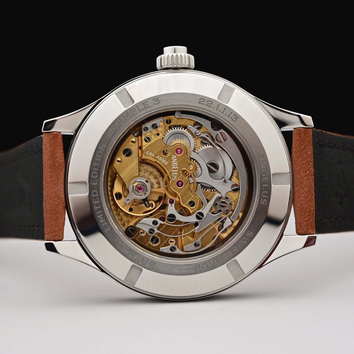 Sapphire caseback showing the hand-wound Calibre A5000, a column-wheel monopusher chronograph with 3N gold bridges and palladium-treated components, inside an engraved limited-edition caseback ring