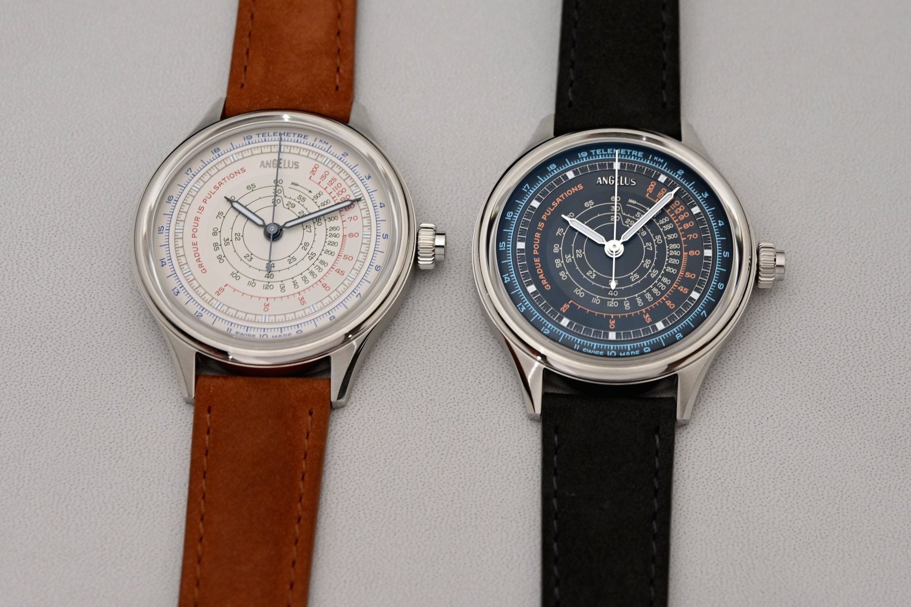 Angelus Instrument de Mesures, both limited editions side by side: ivory-white dial ref. OCHDS.I01A.V1477S on a tobacco calf strap at left and ebony-black dial ref. OCHDS.B01A.V1476S on a black calf strap at right, each carrying telemeter, pulsometer and tachymeter scales