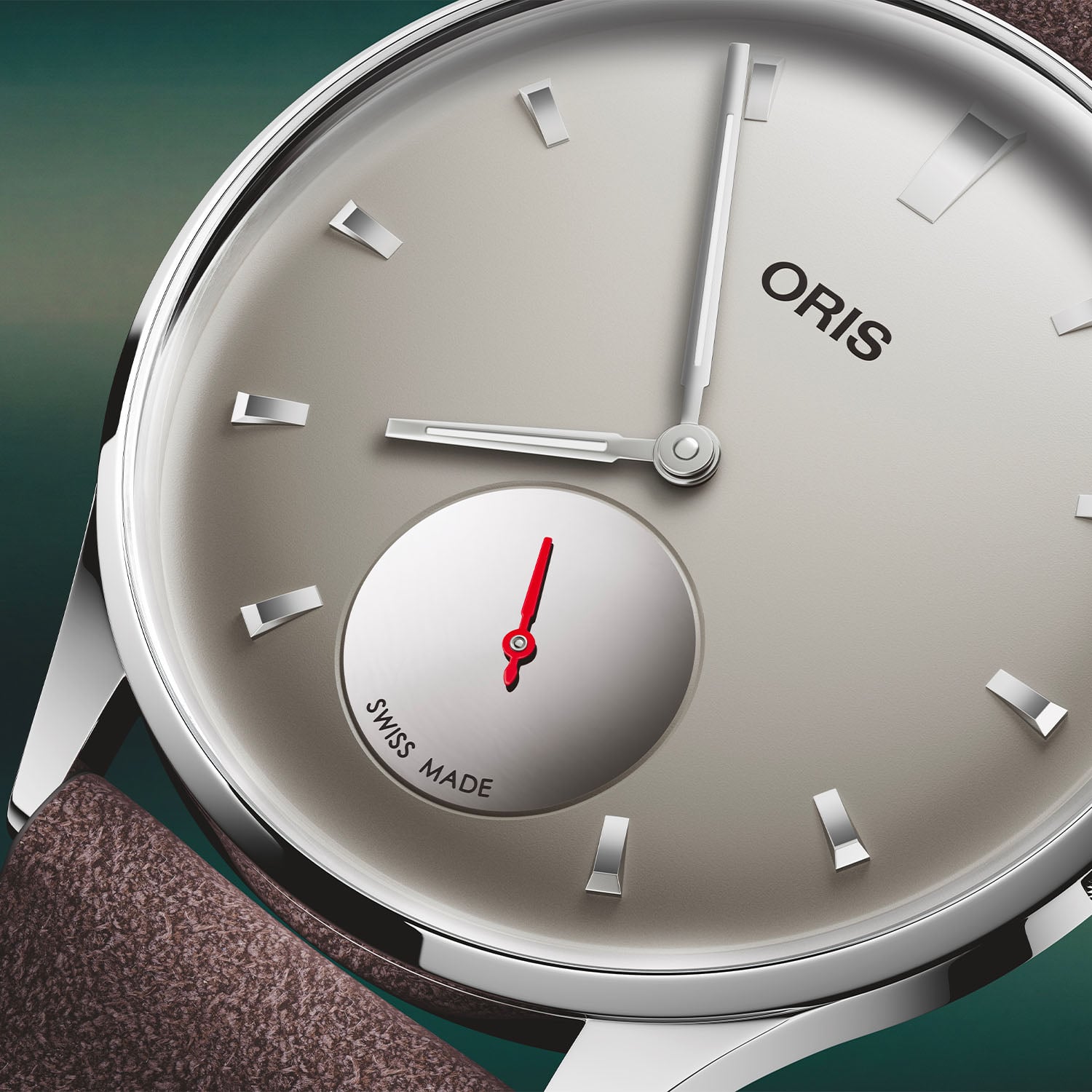 Macro of the Oris Hölstein Edition 2026 dial showing the polished wedge-shaped hour markers, the ORIS logo, and the sunken mirror-finish small-seconds sub-dial at six with a red seconds hand above the words SWISS MADE