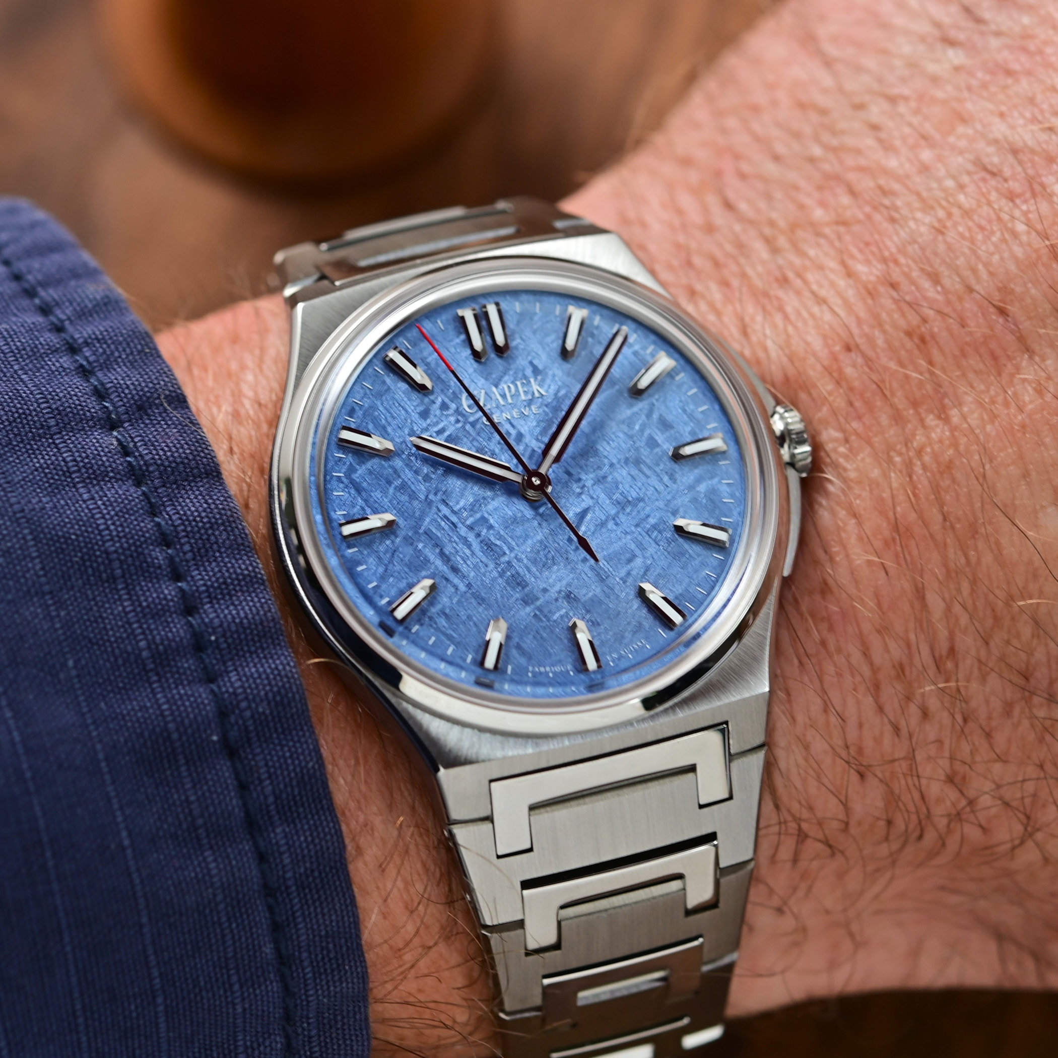 Czapek Antarctique Frozen Meteor 40.5mm on the wrist beside a navy cuff, the blue Gibeon meteorite dial catching light across its crystalline texture, steel case and integrated V2 bracelet