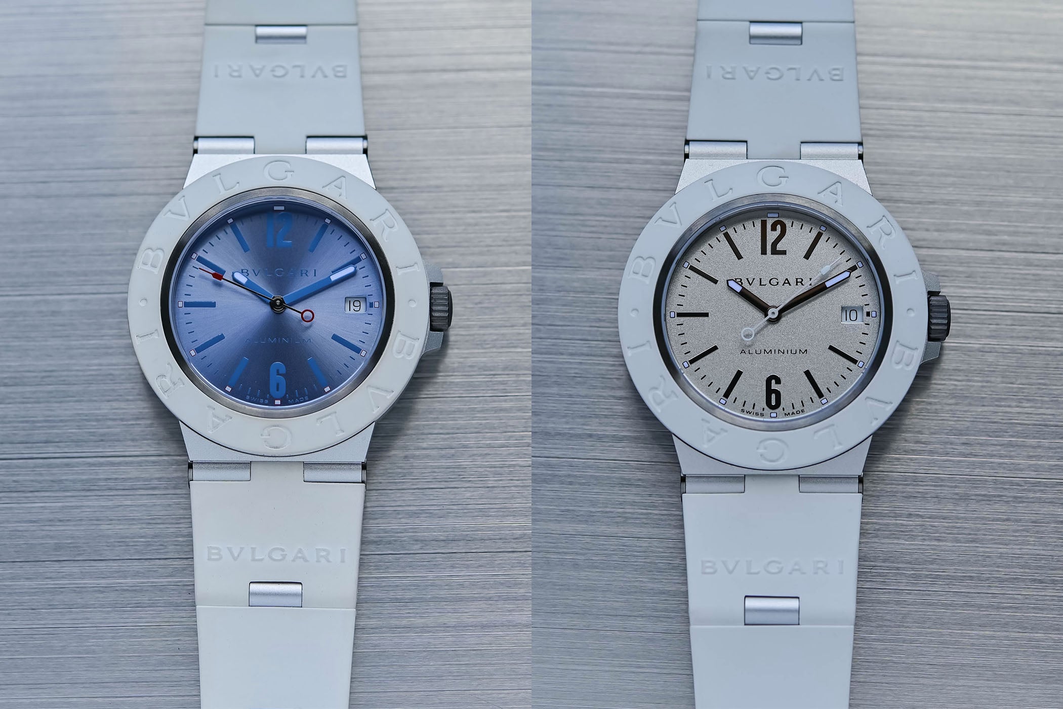 Bulgari Aluminium Ice Blue ref. 104309 and White ref. 104335 side by side on brushed steel, 40mm sandblasted aluminium cases with white rubber bezels engraved Bvlgari Bvlgari and integrated white rubber straps with aluminium links