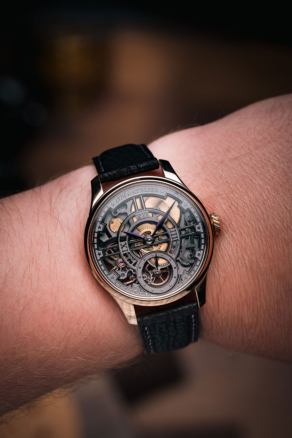 1776 Atelier Liberty 250 on the wrist, 41mm rose gold case, grey openworked dial with Roman numerals and star markers, plum-coloured hands, black leather strap