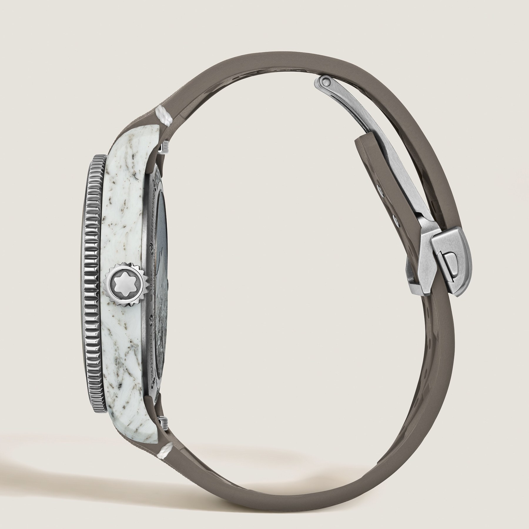 Side profile of the Montblanc 1858 Geosphere Mount Elbrouz showing the mottled white and grey volcanic-ash composite midcase between the titanium bezel and caseback, coin-edge bezel grip and light brown rubber strap with folding clasp