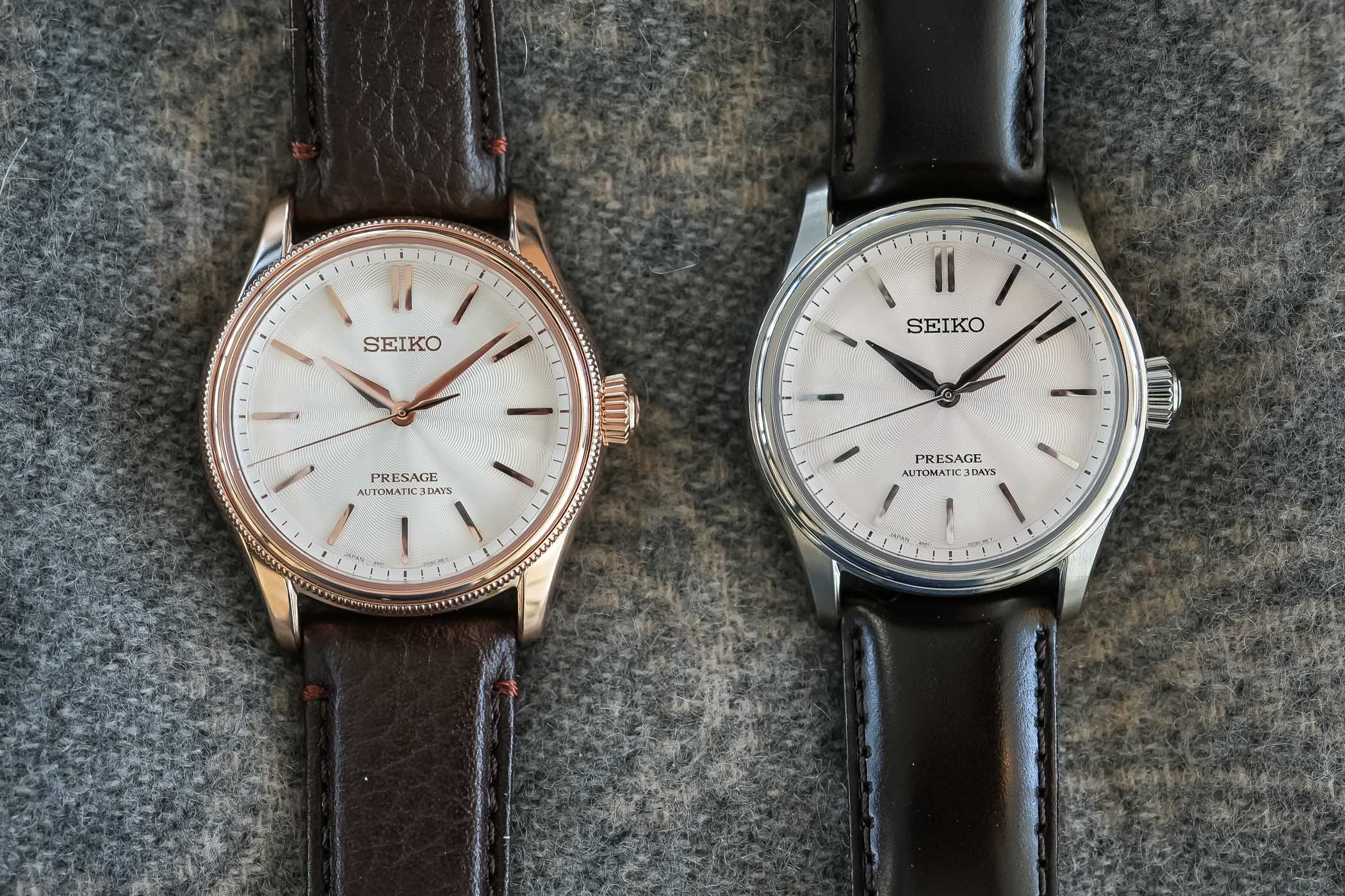 The two leather-strap references side by side on grey wool: the HCC008 in its pink-gold-plated beaded-bezel case on brown leather, next to the steel-cased HCC003 with sakura-iro pink dial on a dark strap