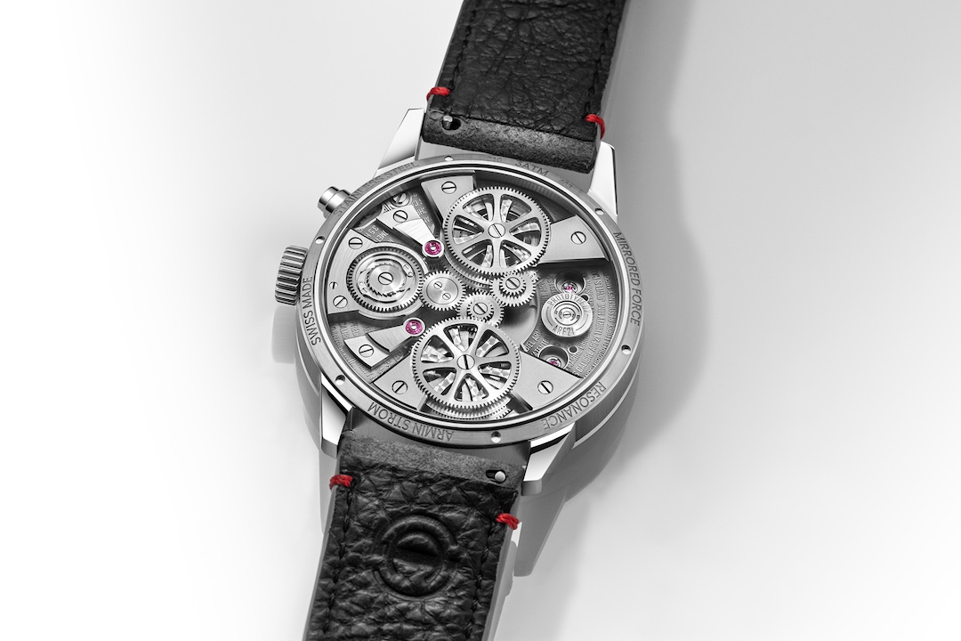 Caseback of the Mirrored Force Resonance showing the manually wound movement, twin going trains and skeletonised bridges with a large exposed gear train, engraved ARMIN STROM and MIRRORED FORCE RESONANCE around the rim, on a black leather strap