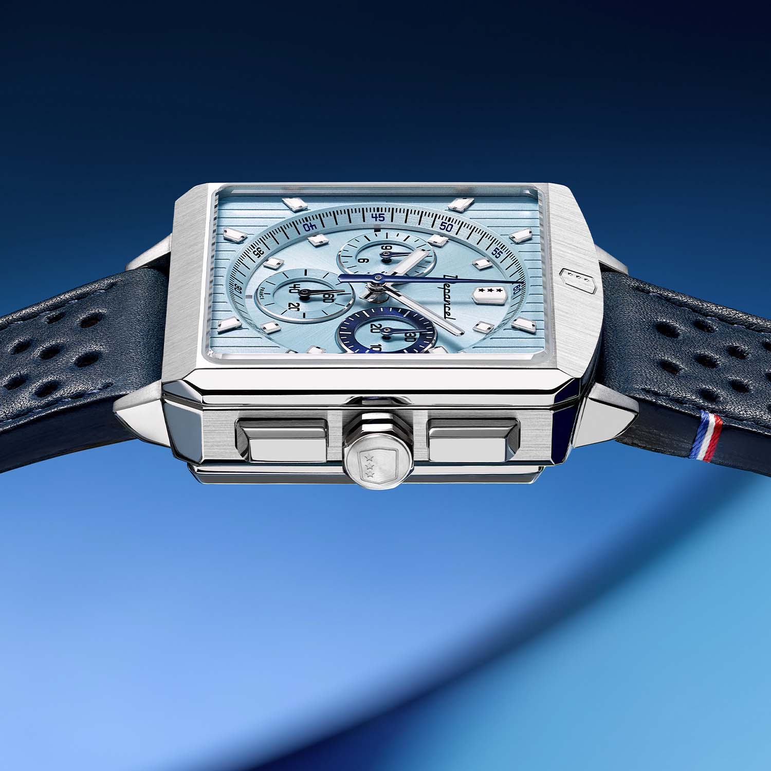 Side profile of the Serie-R Ice Blue showing the case flank, the two polished rectangular chronograph pushers either side of the octagonal crown stamped with the Depancel shield, and the sloping bevelled top edge of the case