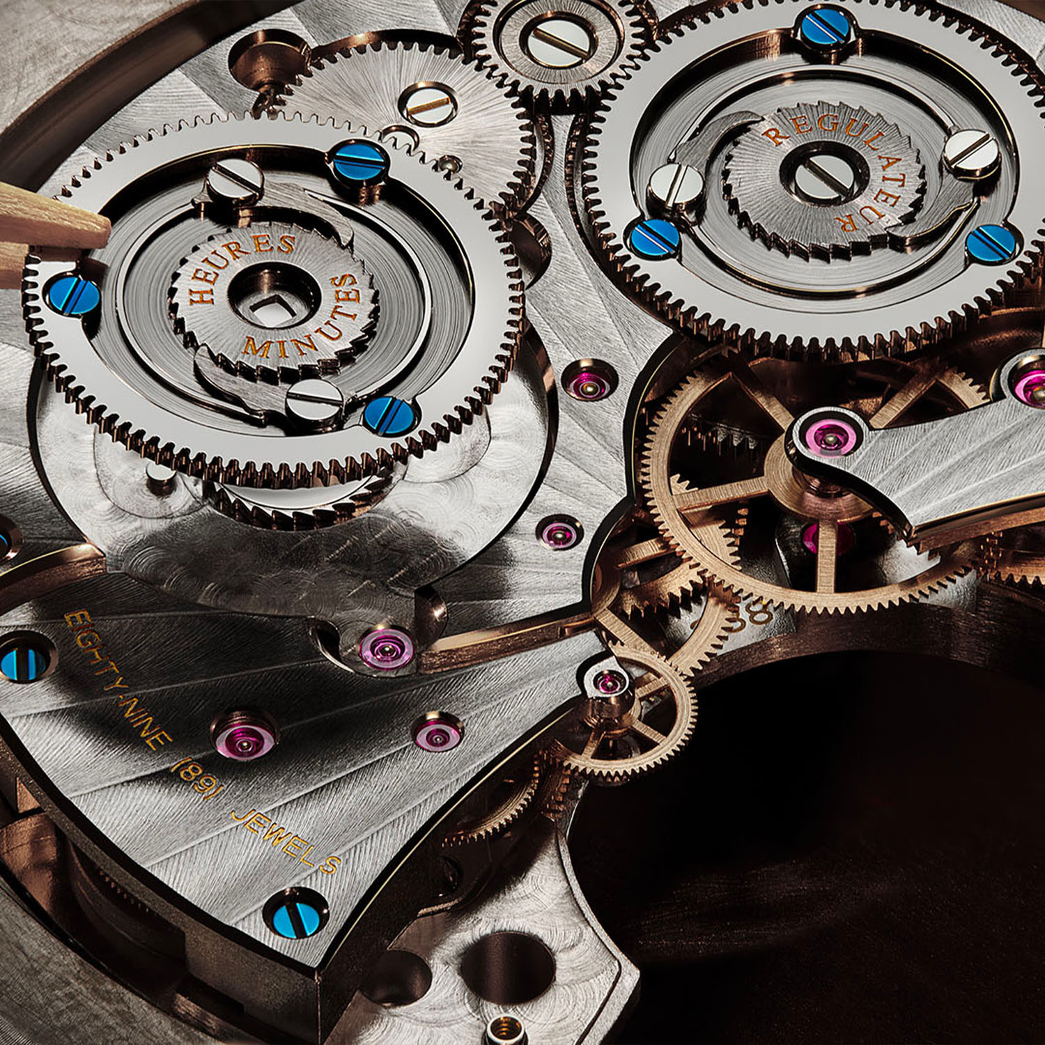 Movement macro of calibre 388 showing the twin barrels, Geneva striping on the bridges, blued screws and ruby jewels, with HEURES MINUTES and REGULATEUR engraved on the two power reserve wheels and EIGHTY-NINE (89) JEWELS in gold lettering
