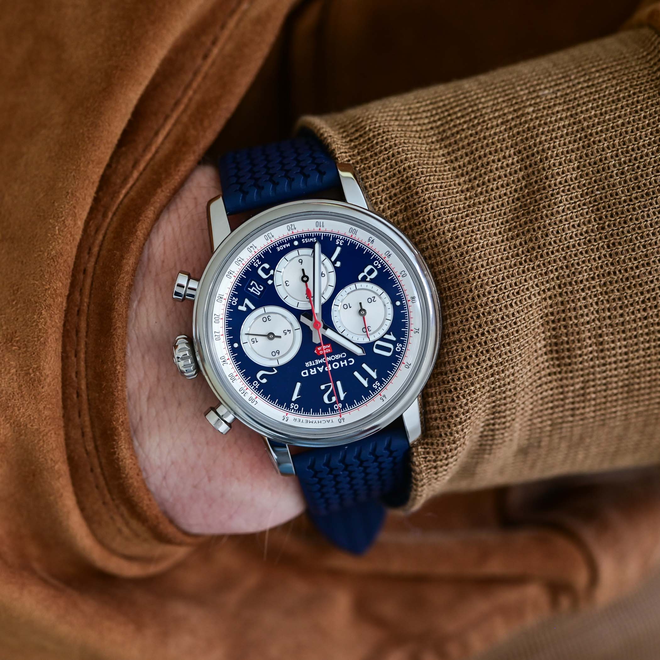 The French edition on the wrist, varnished blue dial with silvered counters and a red central chronograph hand, on a blue tyre-tread rubber strap