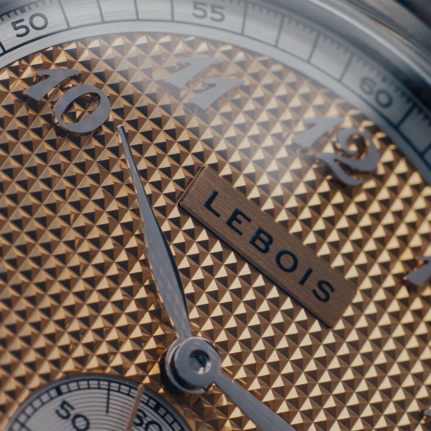 Macro of the Lebois & Co Clous de Paris dial, a rose-gold hobnail field of pyramids catching light with an applied silver LEBOIS plaque