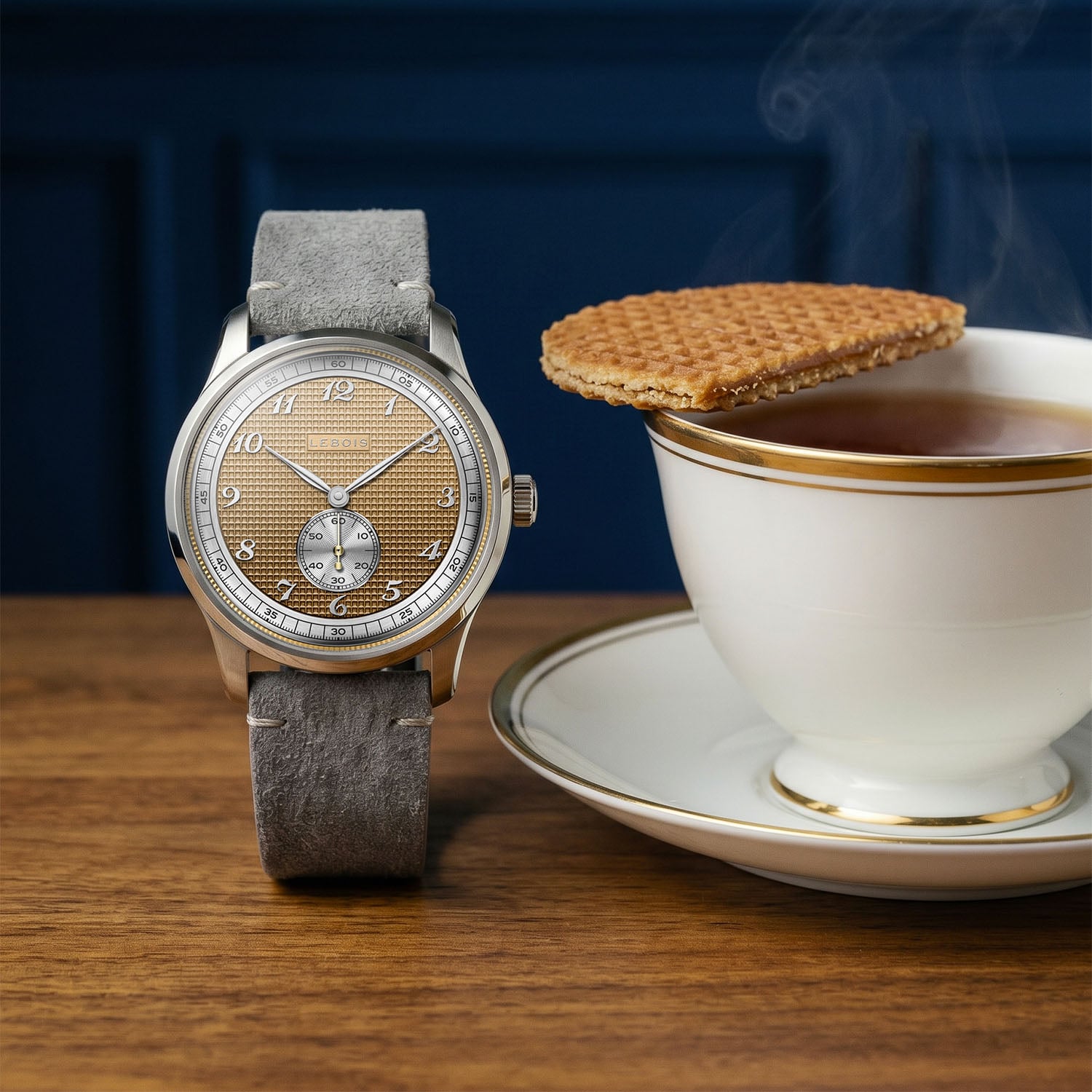 The Lebois & Co Stroopwafel beside an actual stroopwafel resting on a teacup, the caramel waffle-textured dial echoing the biscuit