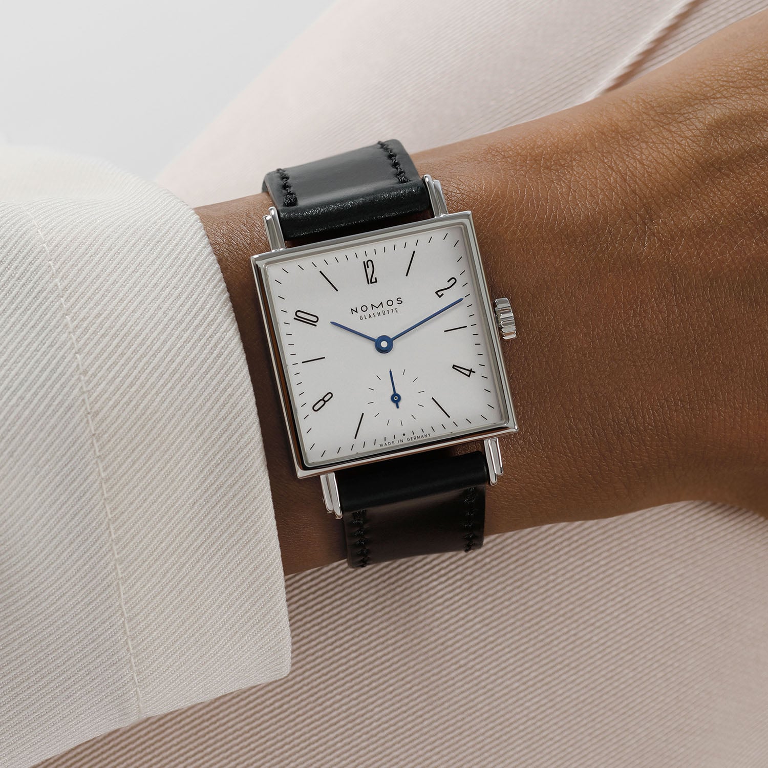 Nomos Tetra 27 white on the wrist, square case reading Made in Germany at the base of the dial, on a black leather strap