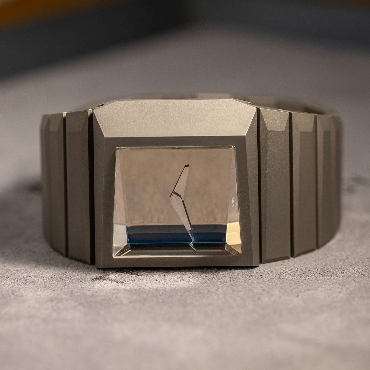 The Breutalist head-on, the asymmetric faceted titanium case and integrated single-link bracelet, the mirror dial reflecting blue light