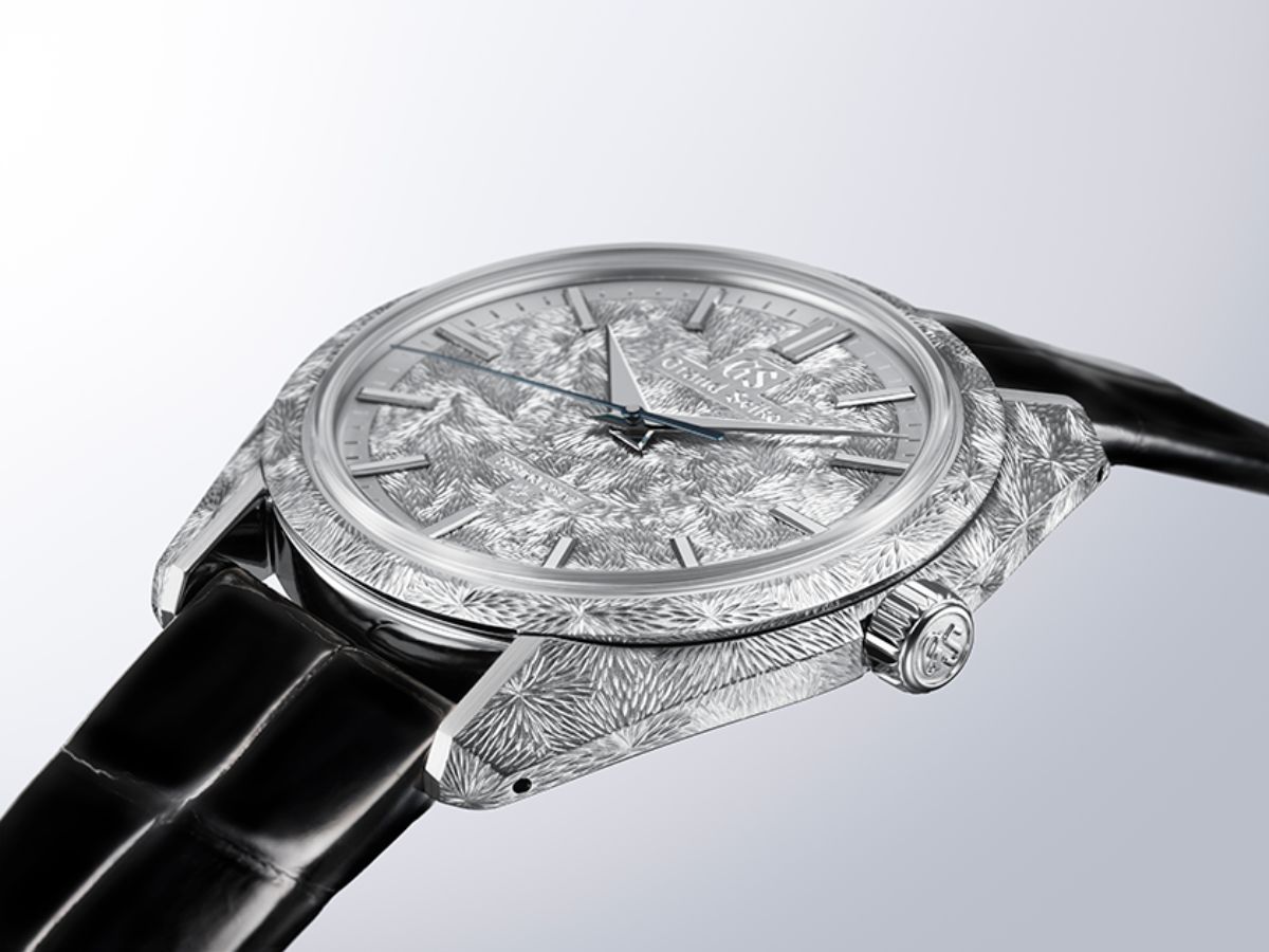 Profile view of the Grand Seiko SBGZ011 showing the flowing-water engraving carried down the platinum case flank and onto the crown, on a black crocodile strap