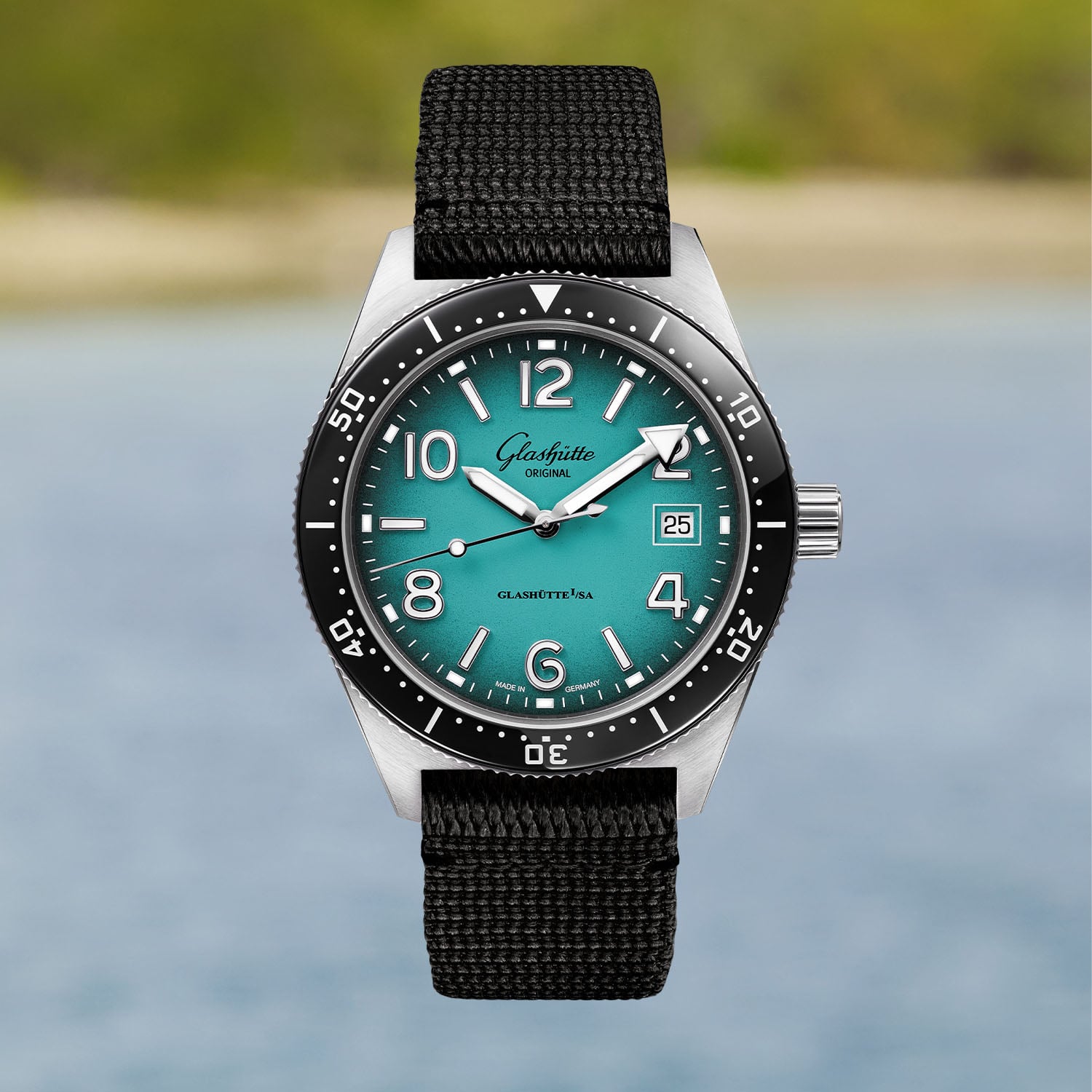 The 39.5mm SeaQ Northern Tide on a black synthetic strap, studio front view showing the turquoise dial, black ceramic bezel and rhodium-plated numerals
