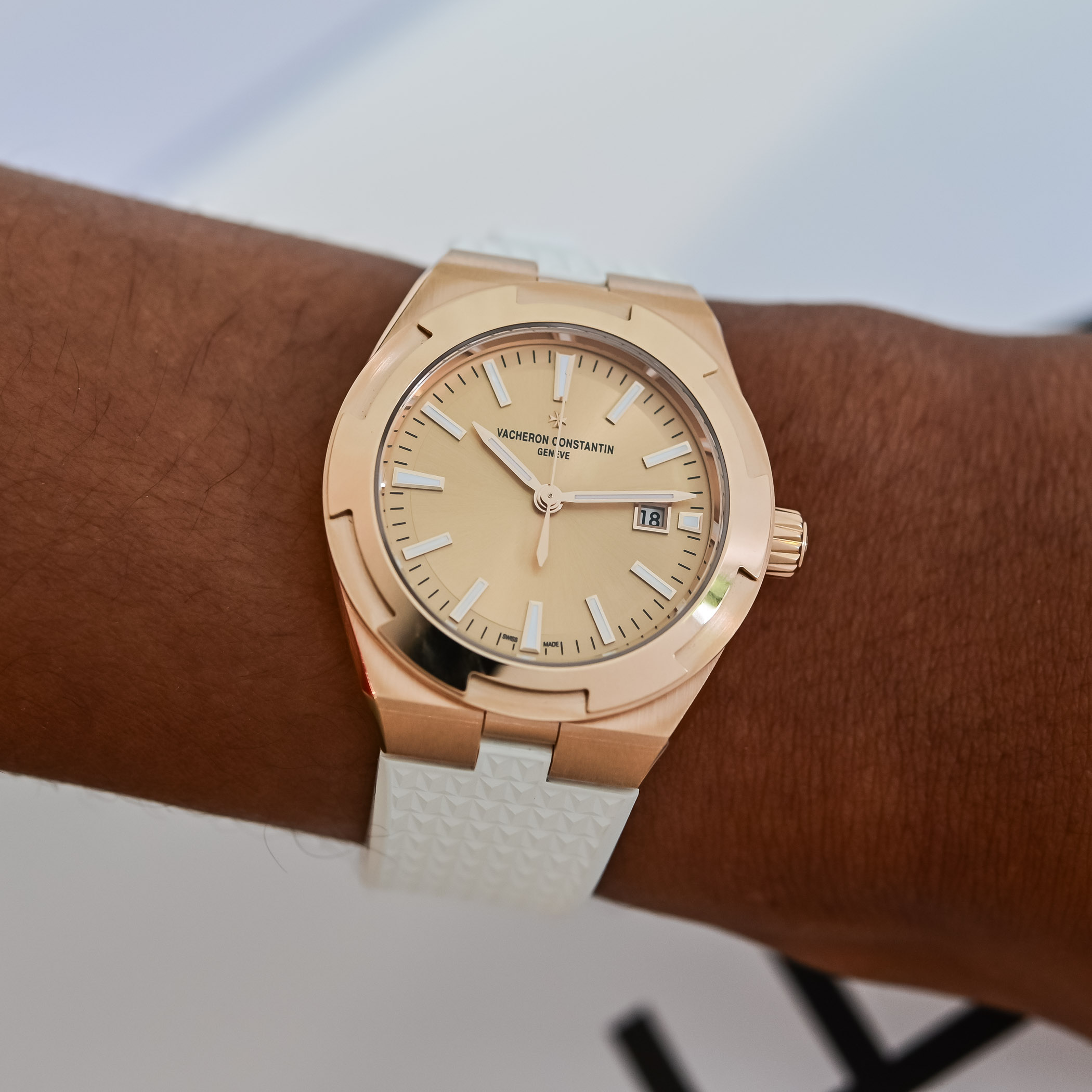 The pink gold Overseas 34.5mm worn on the wrist on its white textured rubber strap, one of three interchangeable options supplied with the watch