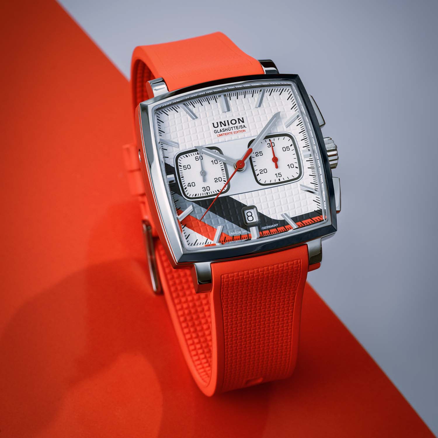Three-quarter view of the Averin Sachsen Classic 2026 on the red rubber strap, highlighting the brushed-and-polished square steel case and domed sapphire crystal