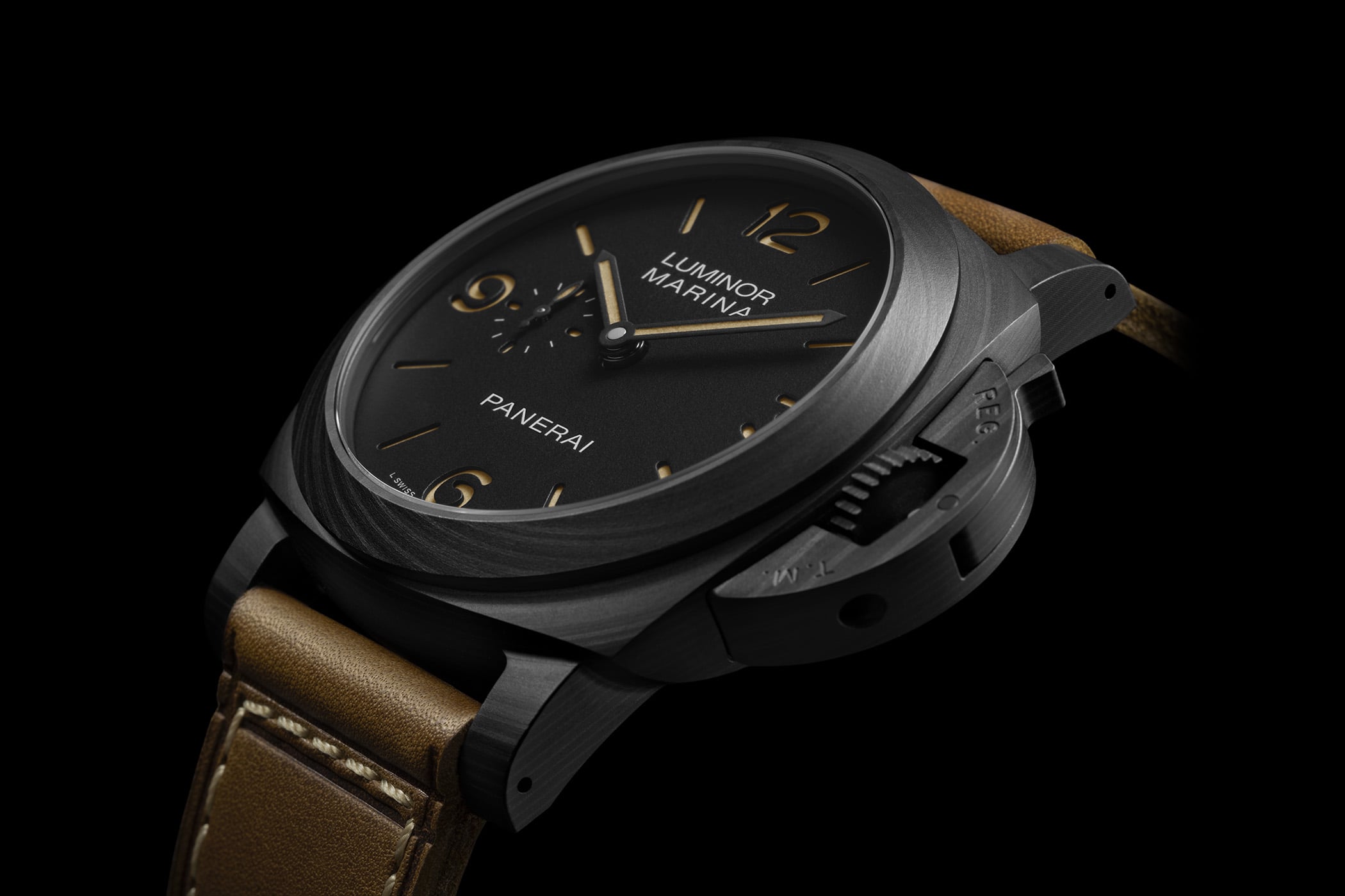 Panerai Luminor Marina PAM01707 in Carbotech, a matte-black marbled carbon-composite cushion case with the crown-protecting bridge, black sandwich dial with aged beige numerals and small seconds at 9, worn on a brown leather strap against a black background