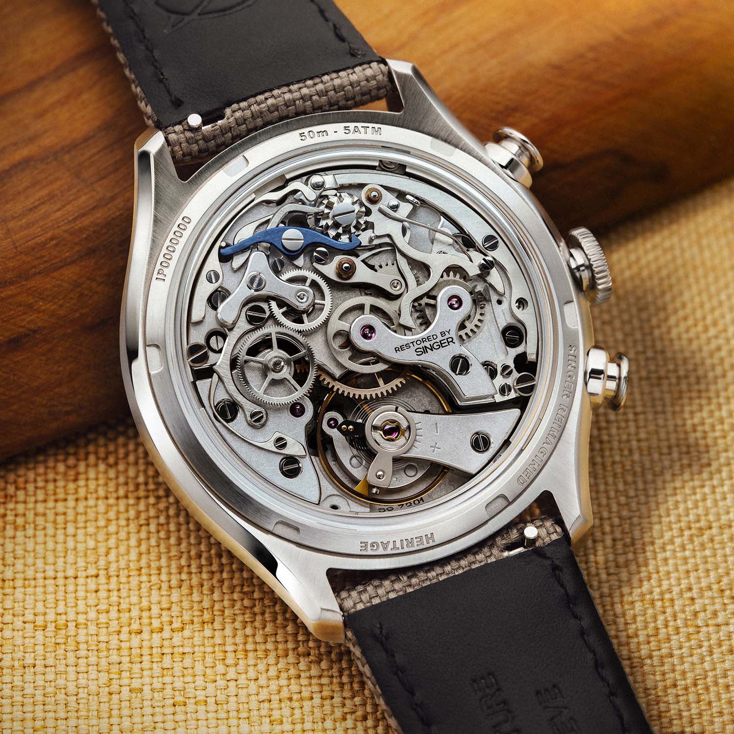 Caseback macro of the restored Valjoux 72, calibre SG7201, showing frosted bridges, a blue ALD switch component and the Restored by Singer inscription on the Y-shaped chronograph bridge
