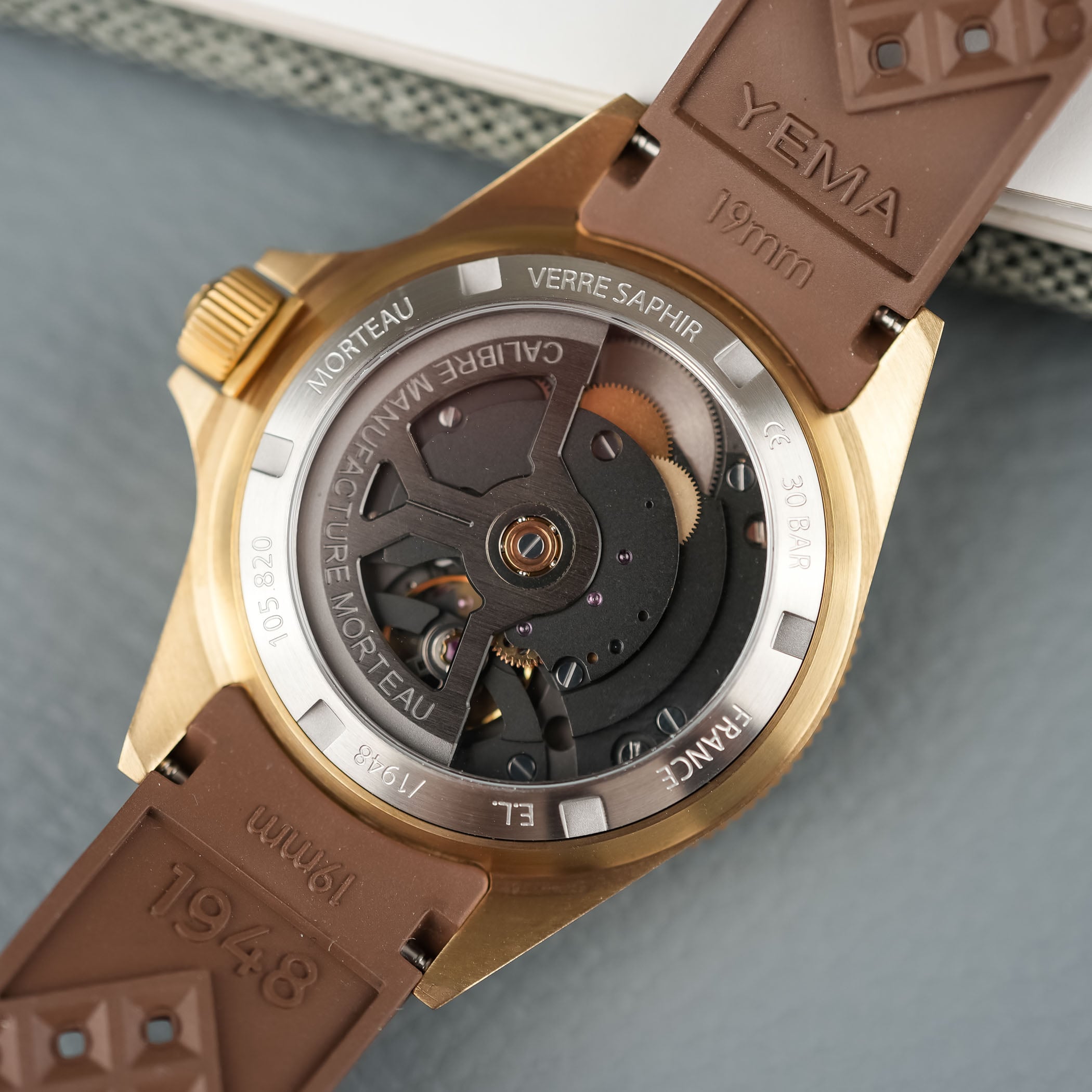 Sapphire caseback of the Yema Superman Bronze showing the in-house automatic Calibre Manufacture Morteau CMM.10 with its skeletonised rotor, engraved Morteau, France and 30 BAR