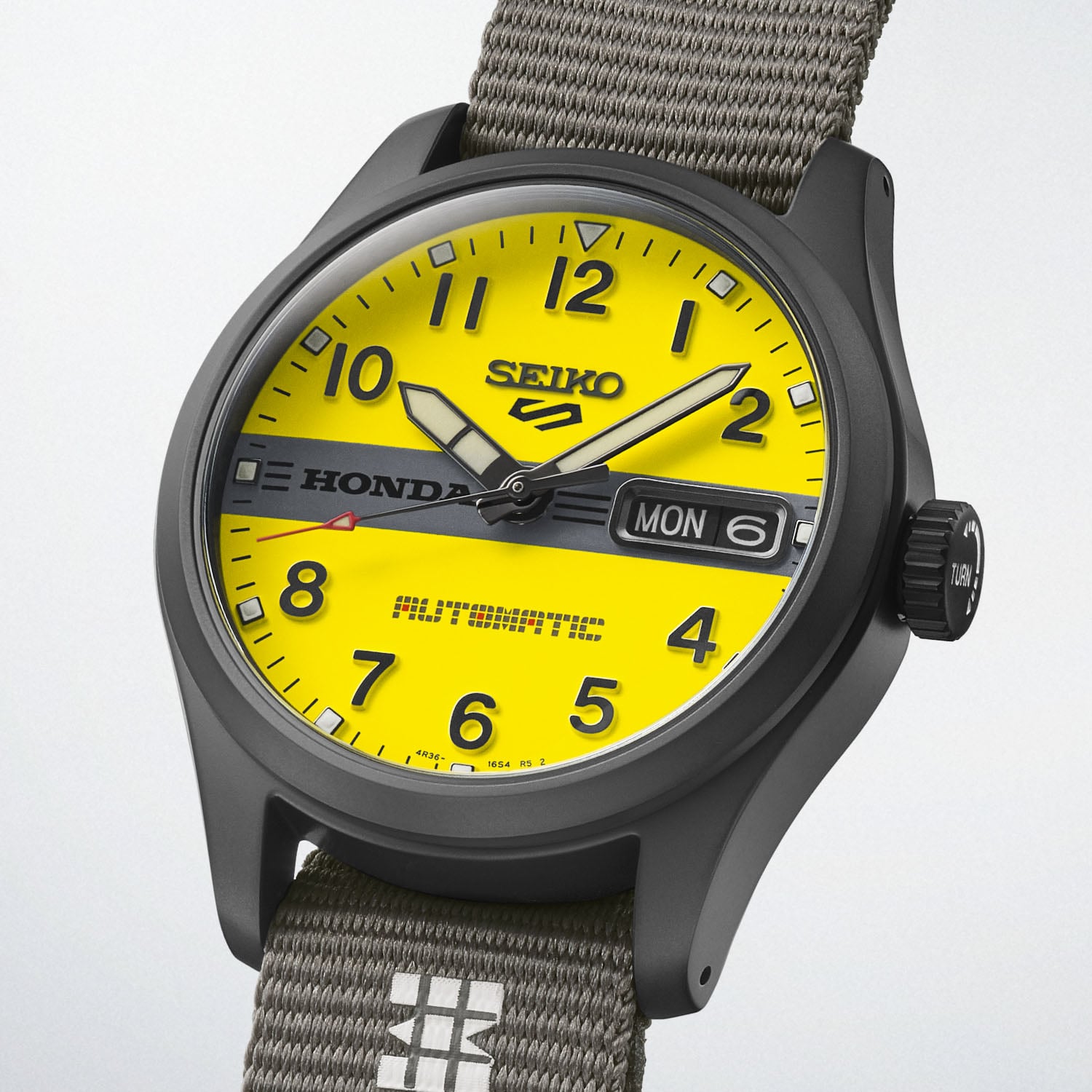 Three-quarter view of the black-coated HDB010 case and the crown engraved TURN, on the grey nylon strap with a Carrying Point keeper