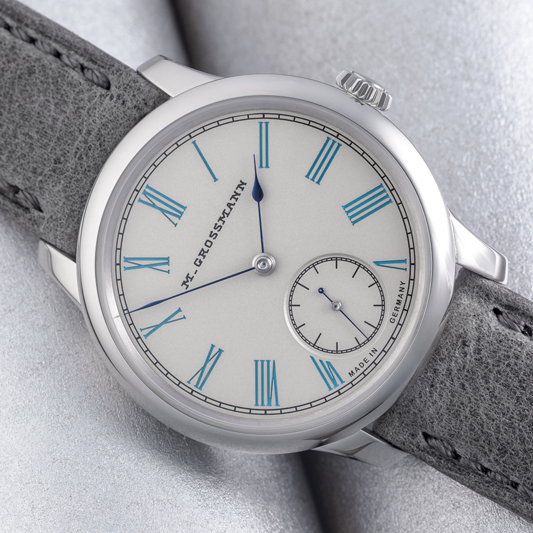 Macro of the Moritz Grossmann Tefnut 36 dial, silvered by friction, with turquoise-lacquered Roman numerals, the 1875 M. Grossmann signature, blued annealed hands and a recessed small seconds at 6