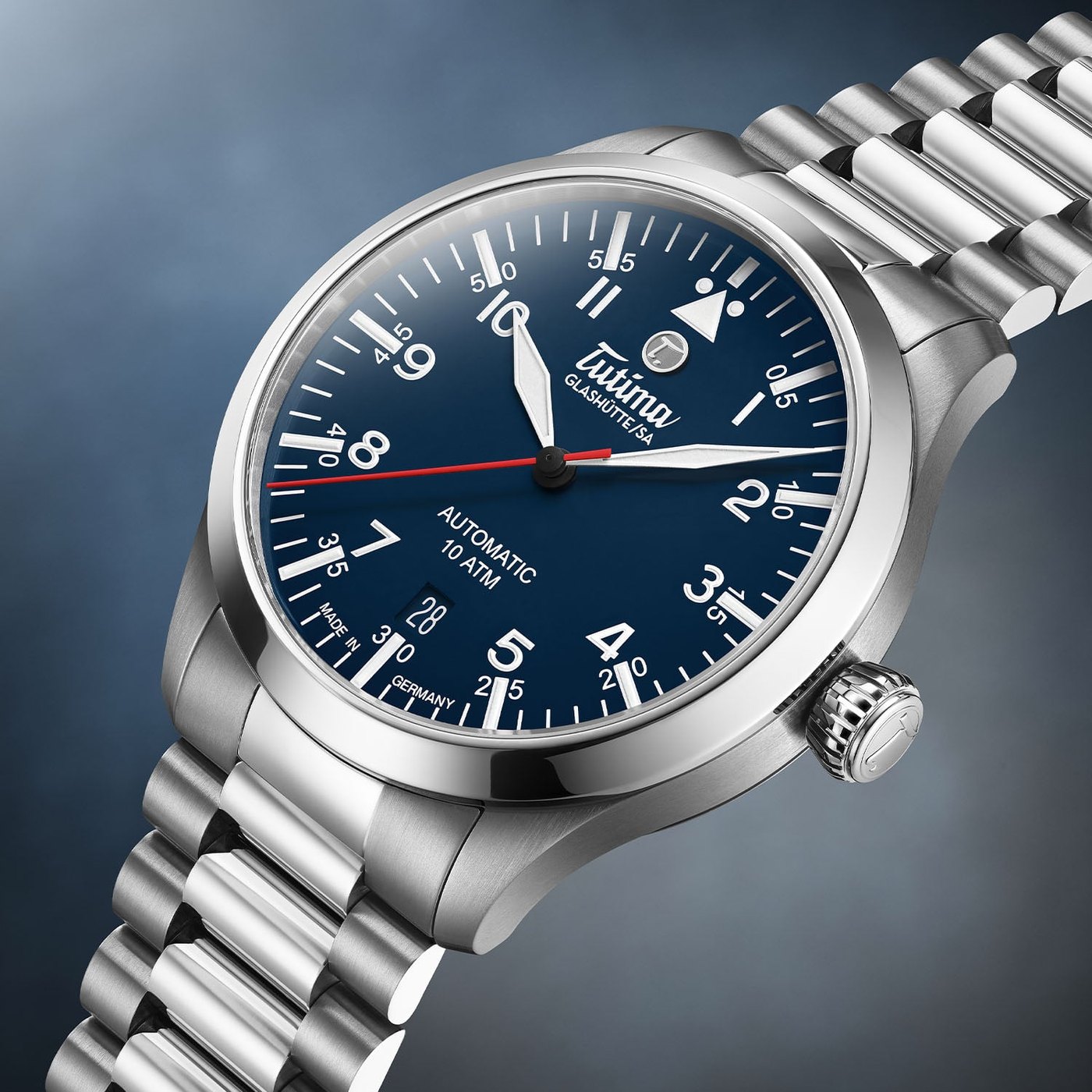 The Tutima Flieger T5 Titanium in blue, reference 6109-03, the sibling to the black model, with a blue lacquered flieger dial, a date at six and a red central seconds hand, on a titanium bracelet