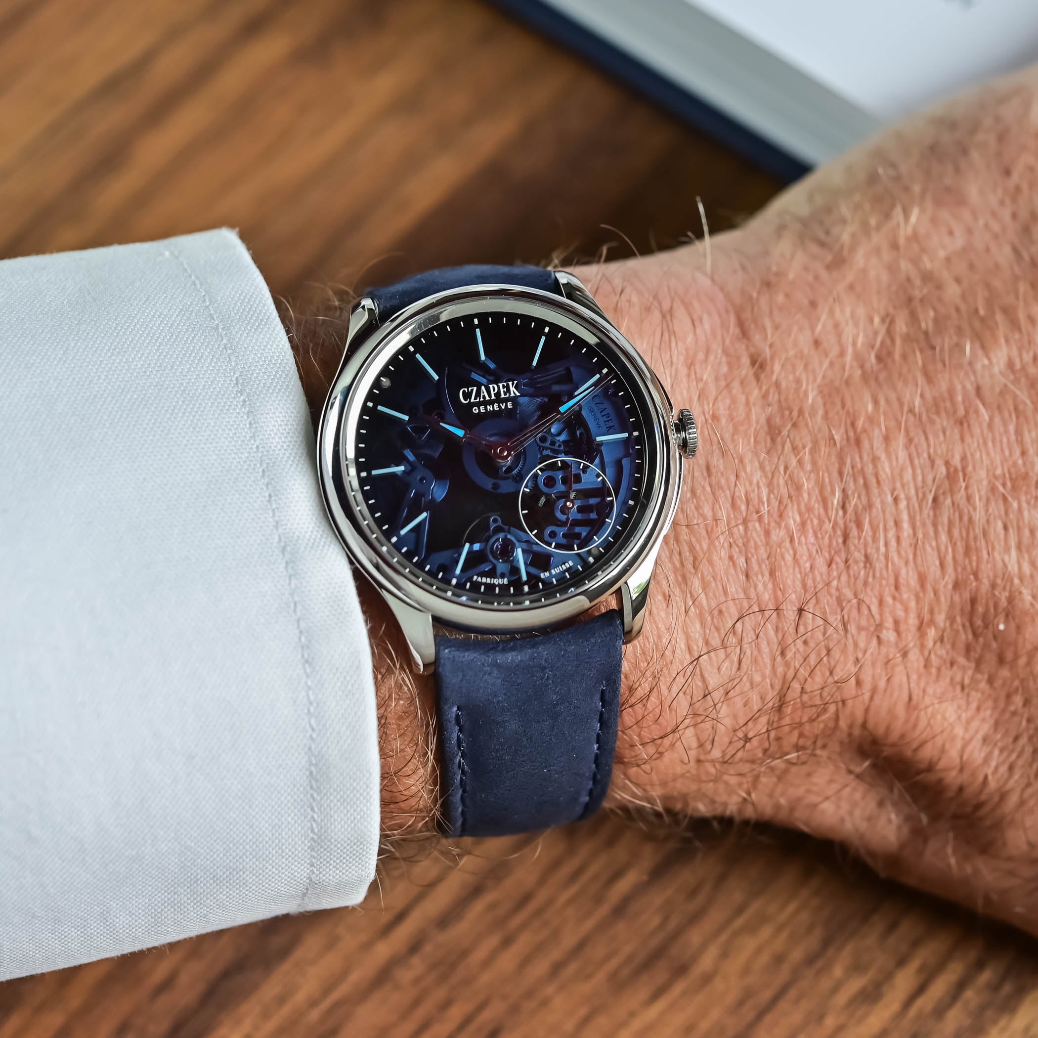 The Promenade Transparencies Aqua Blue on the wrist on its blue nubuck strap, the 38mm polished steel case catching the light while the skeletonised blue dial reads dark from the angle