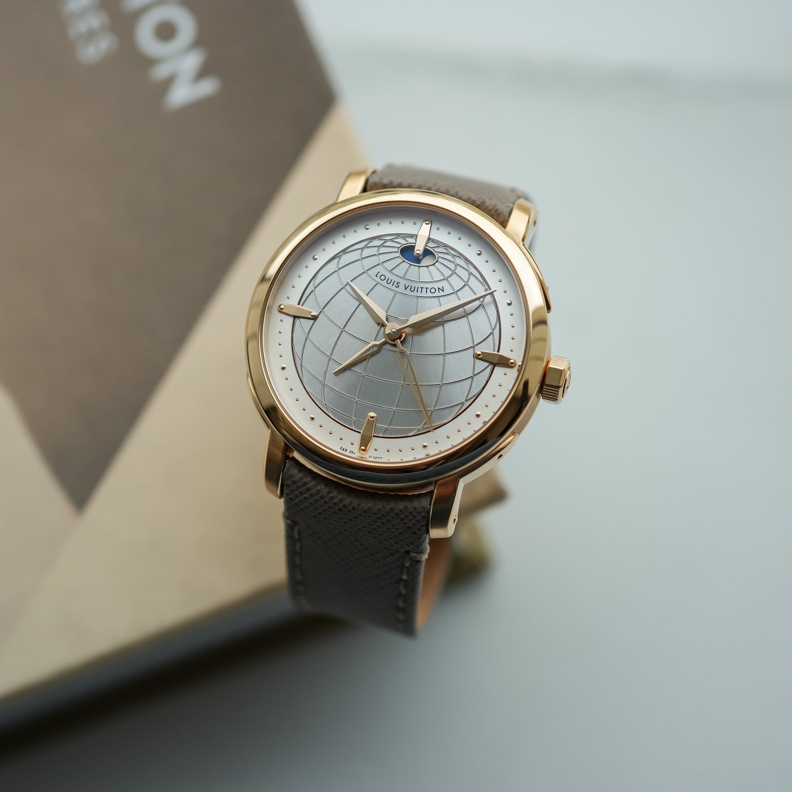 The Escale Twin Zone in rose gold at an angle on its grey saffiano strap, showing the domed sapphire crystal, trunk-rivet gold markers and the octagonal crown