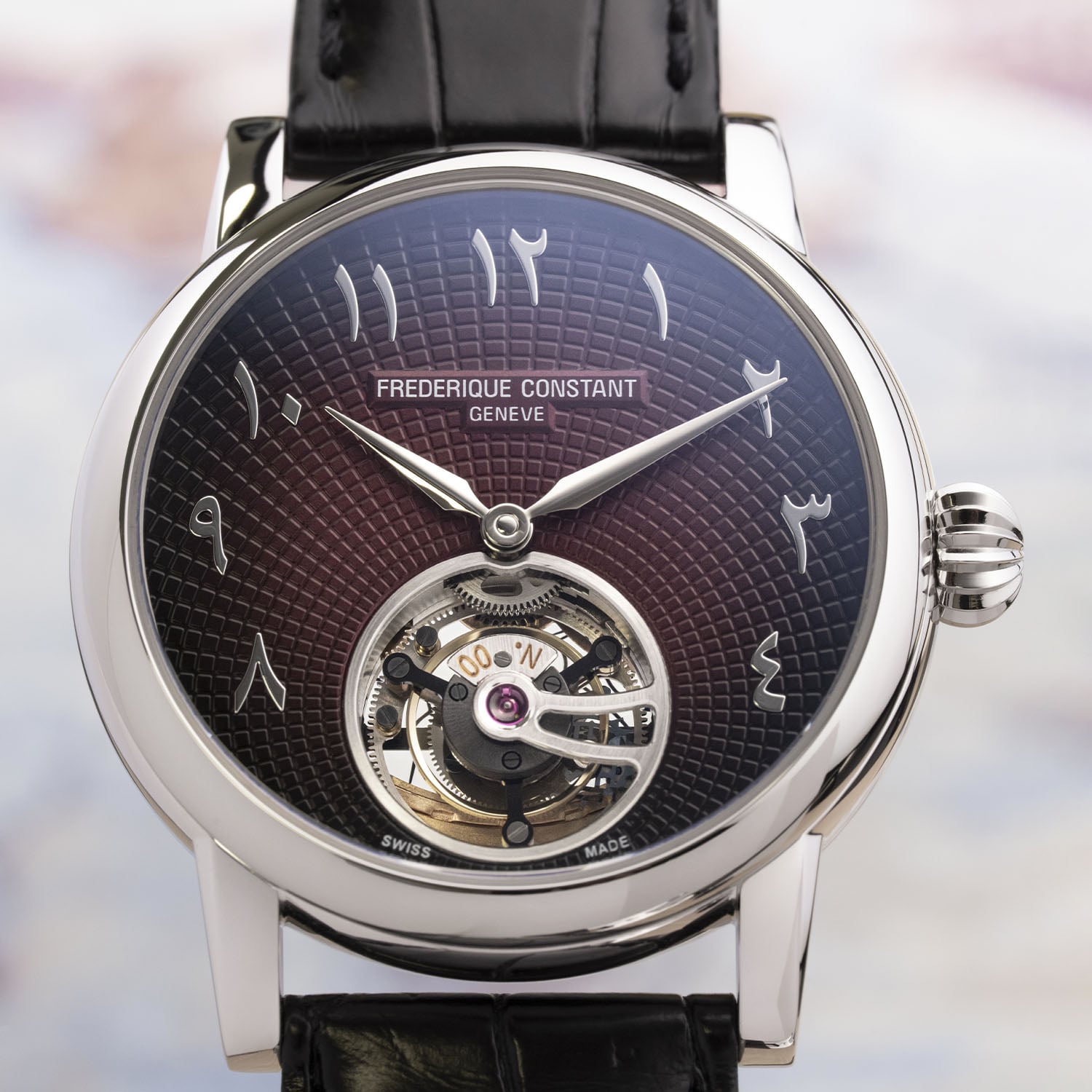 Straight-on macro of the Julie dial, hobnail guilloché running edge to edge around a one-minute tourbillon marked N.00, applied Eastern Arabic numerals and FREDERIQUE CONSTANT GENEVE in a burgundy cartouche