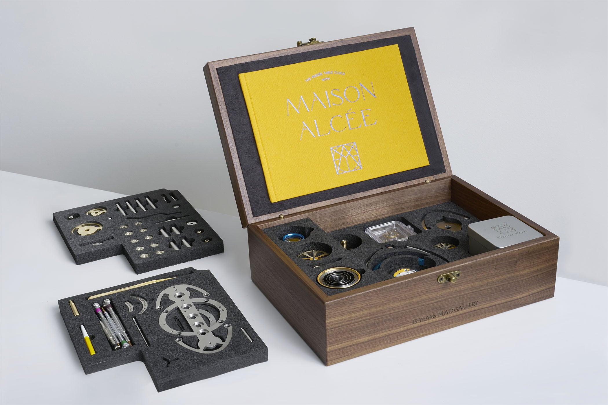 The Nostromo delivered as a kit, an open walnut case with a yellow Maison Alcée instruction book, foam trays of brass and steel components and tools, the box engraved 15 Years MADGallery
