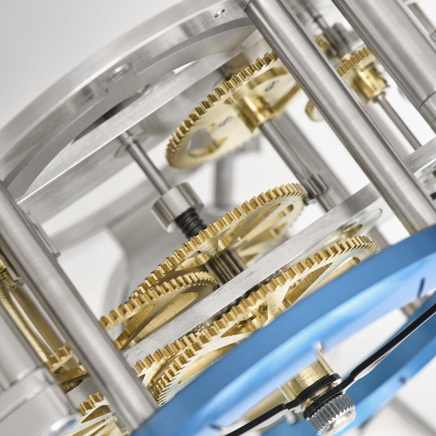 The exposed going train of the Nostromo, brass wheels and steel pillars between two plates with the peacock-blue chapter ring at the lower right