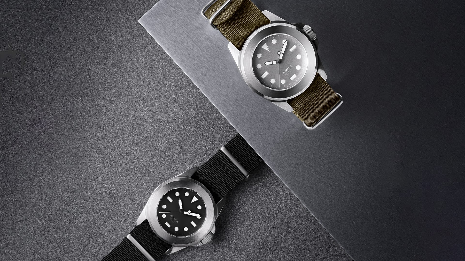 The two Modello Quattro watches, the aluminium-colour U4-AEG on an olive NATO strap above the black-dial U4-AEB, both with a fixed monoblock bezel and drilled lugs