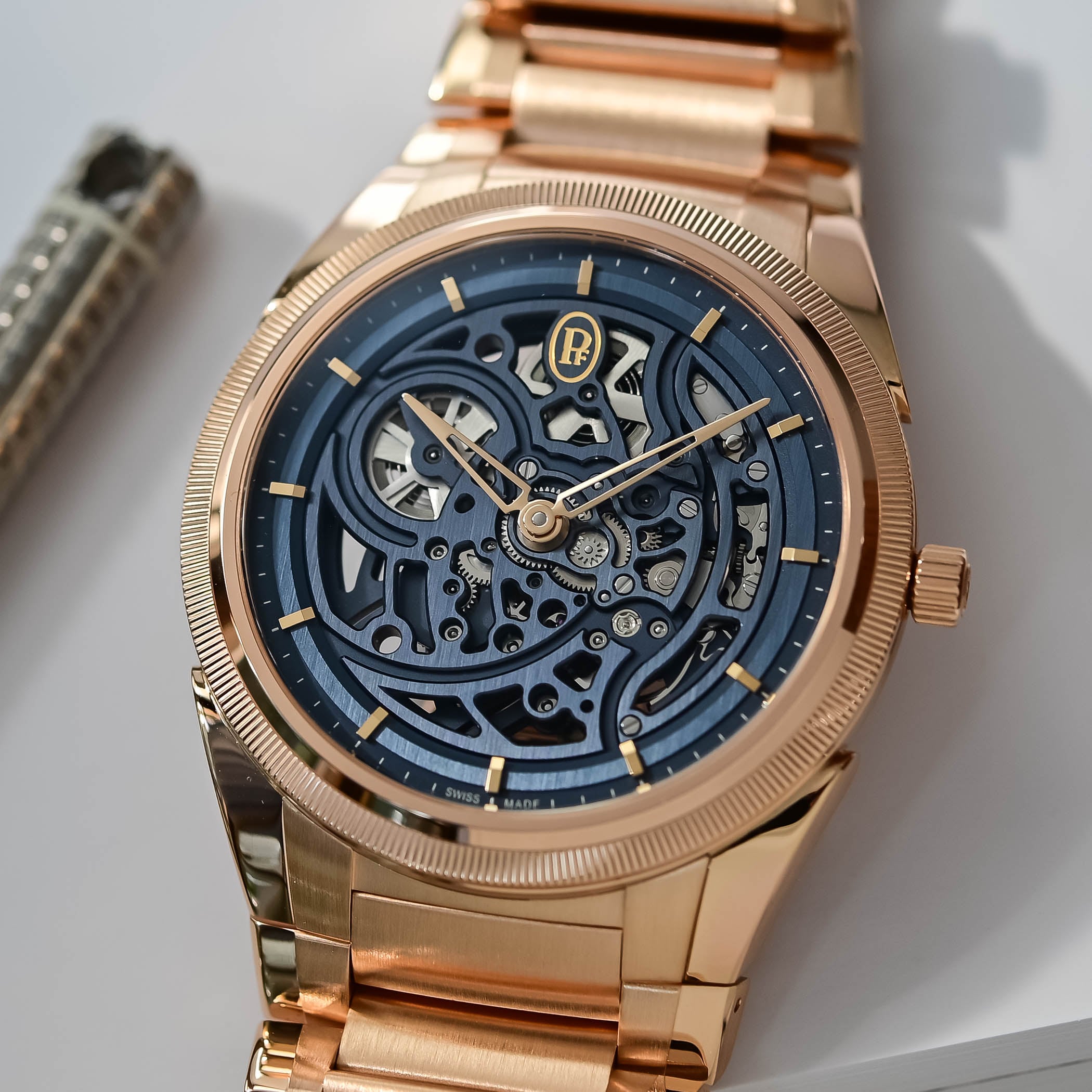 A macro of the Tonda PF Skeleton dial showing the Milano Blue openworked bridges, the gold PF logo and the rose gold delta hands over the visible skeletonised movement