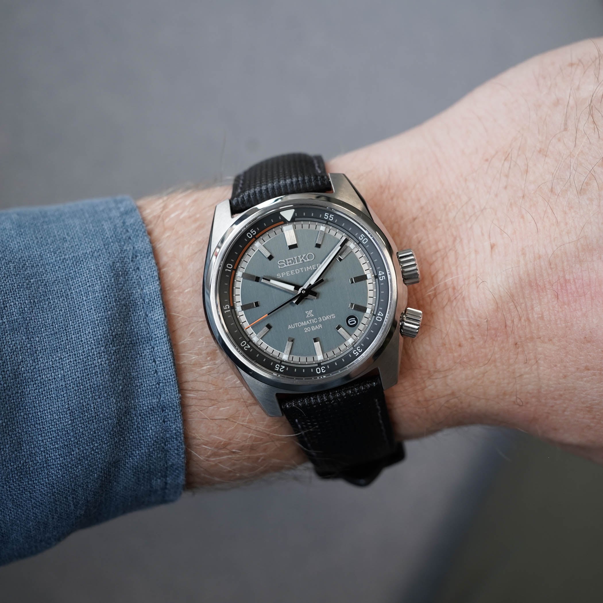 A Seiko Prospex Speedtimer time-and-date model on the wrist, showing the grey dial, orange inner-flange accent, date at 4:30 and twin crowns for the internal bezel