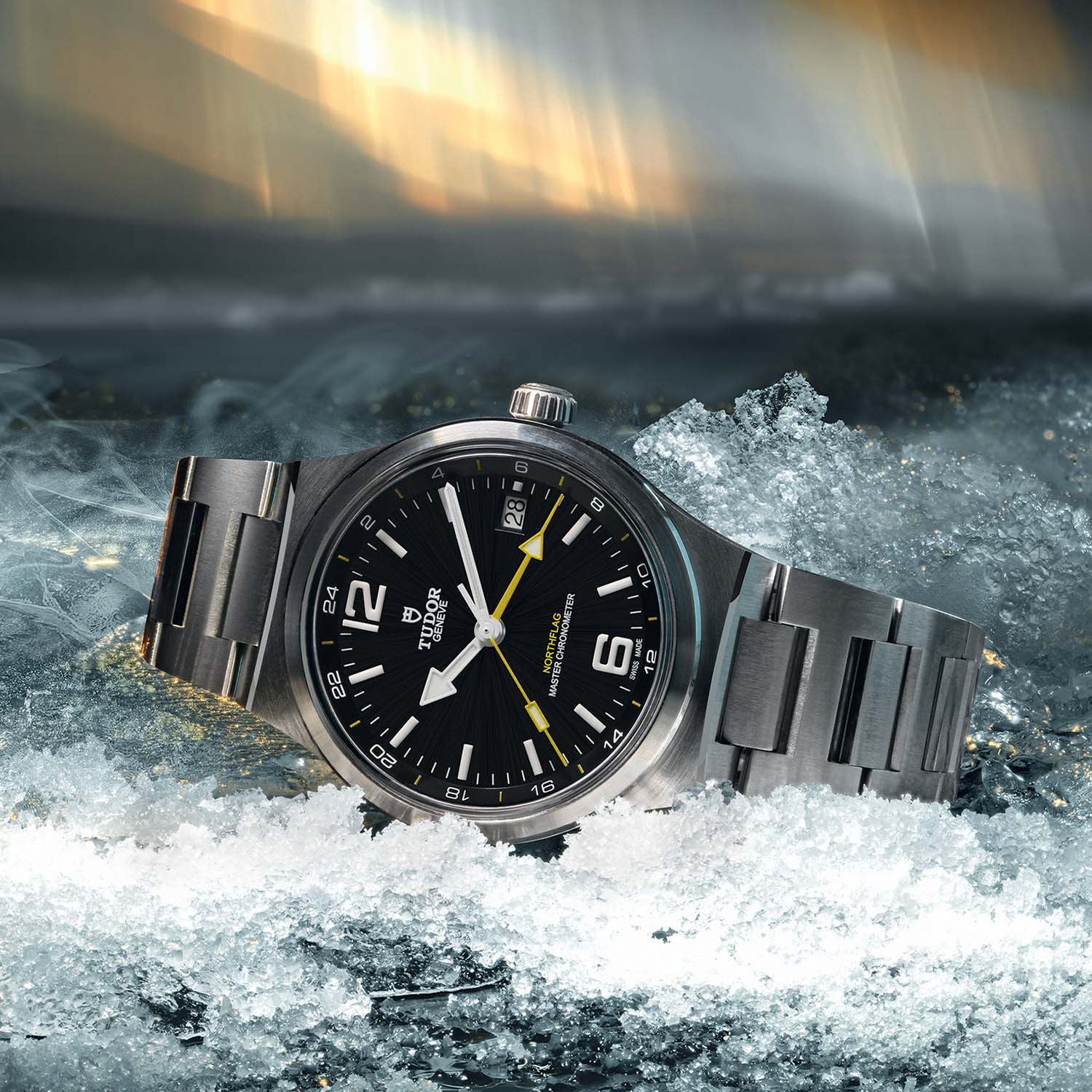 The Tudor Northflag GMT reference 9140G1A0U at an angle on ice, showing the black dial, white Northflag hands, yellow GMT hand and the 24-hour markings on the inner flange