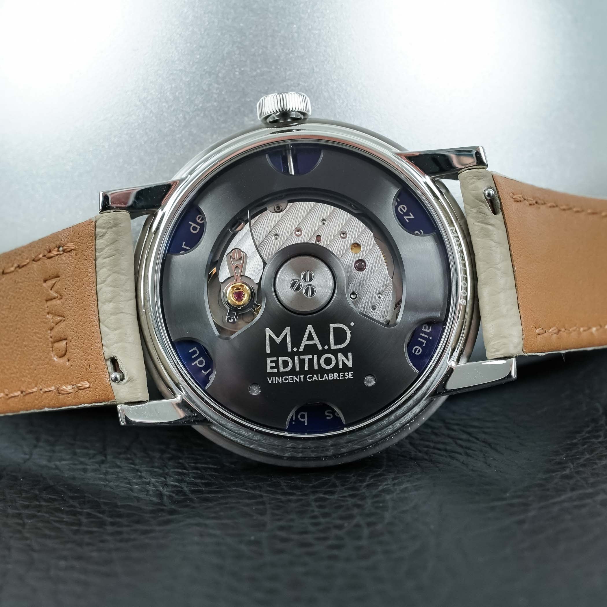 The engraved sapphire caseback of the M.A.D.3, reading M.A.D Edition Vincent Calabrese, with the automatic movement and winding rotor visible
