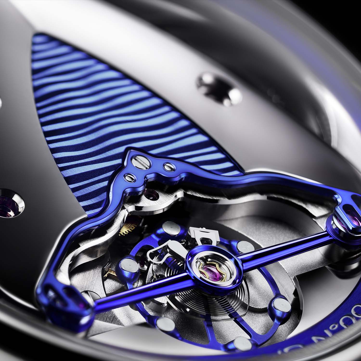 A close macro of the DB2144V3, the mirror-polished blued titanium deltoid bridge over the titanium balance wheel with grey gold inserts and blued spokes, beside a wave-guilloche panel