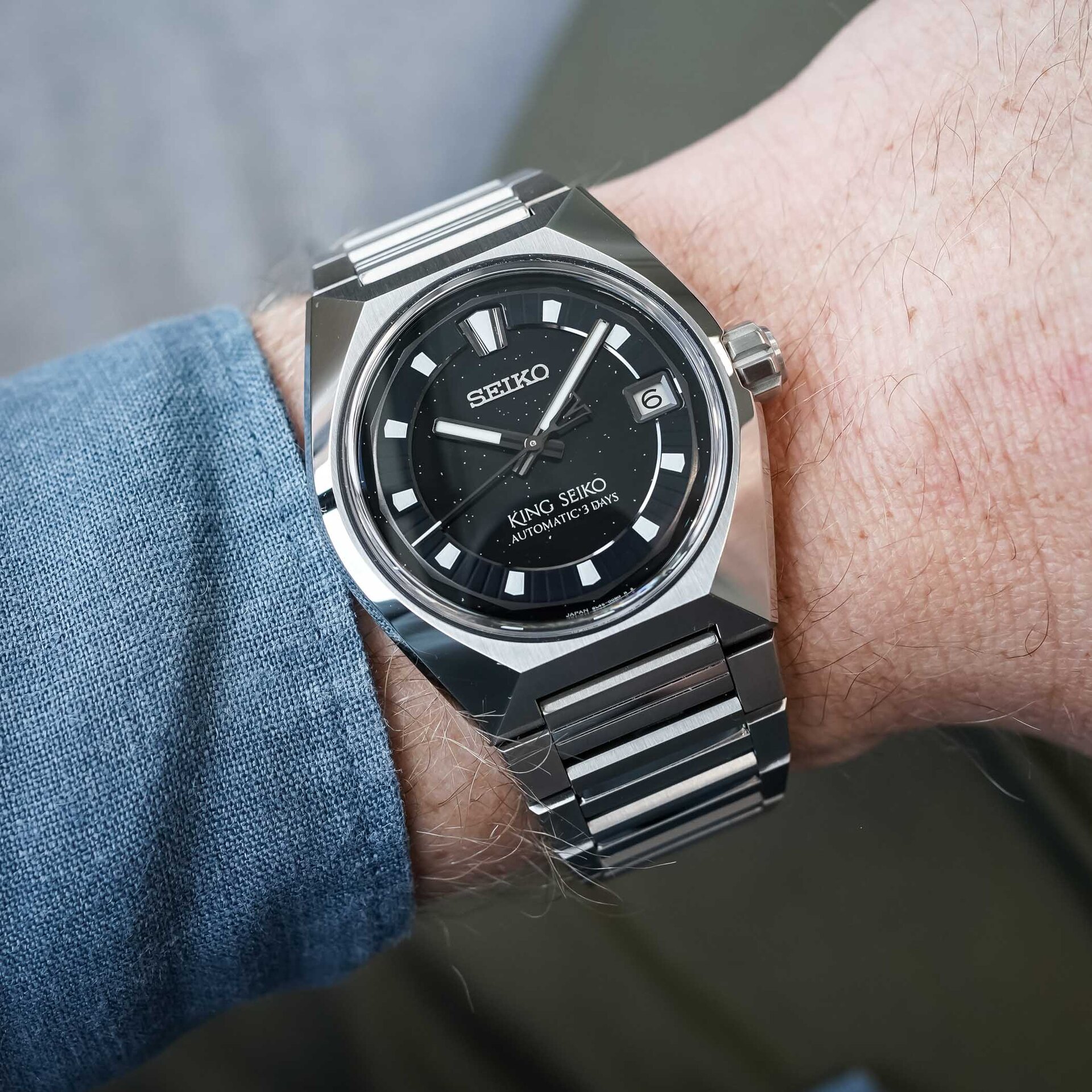 The King Seiko Vanac HKF005 on the wrist, the faceted steel case and integrated bracelet catching the light and the dark dial reading as near-black