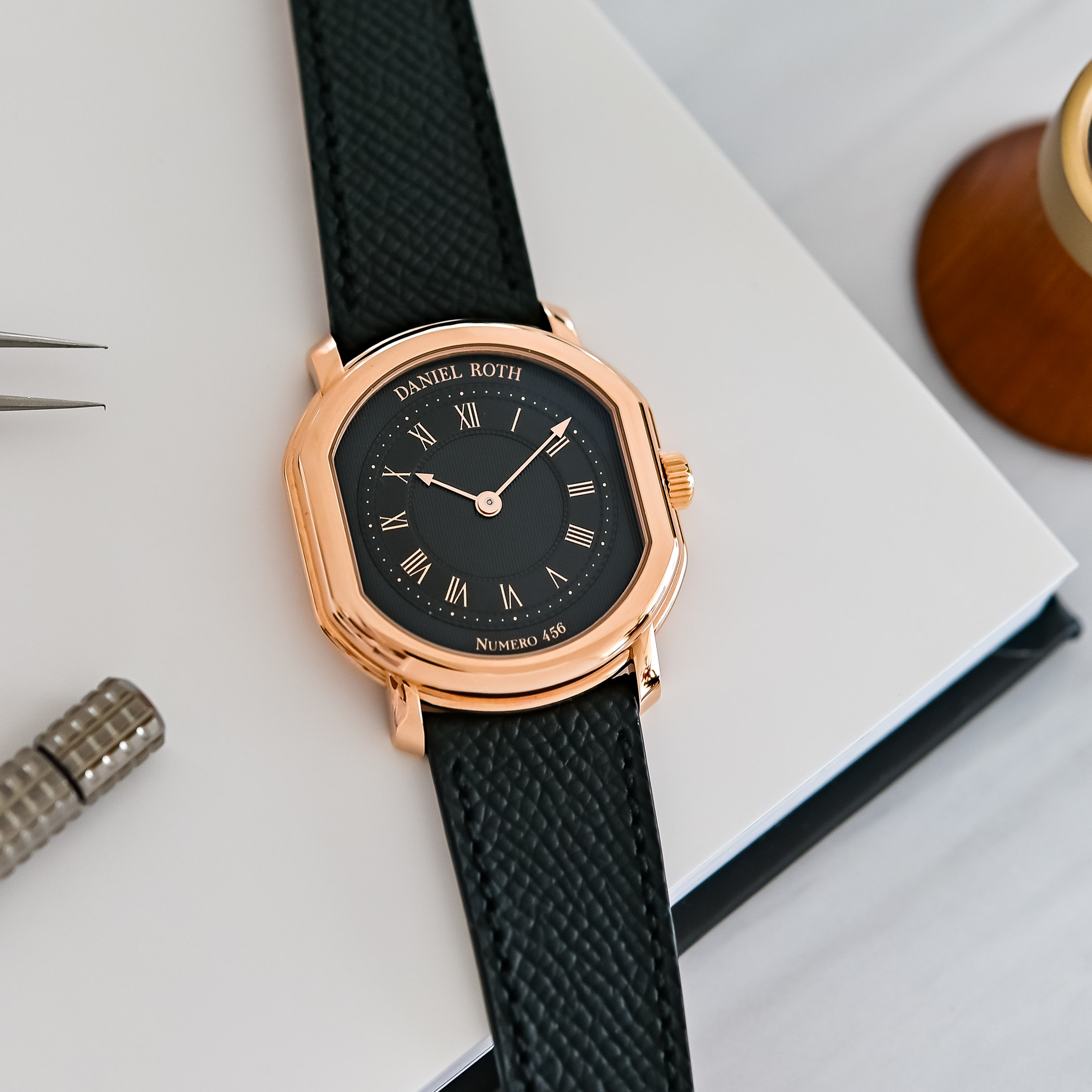 Angled view of the Daniel Roth Extra Plat, the polished 5N rose-gold double-ellipse case and central gadroon over the black gilt guilloche dial marked Numero 456