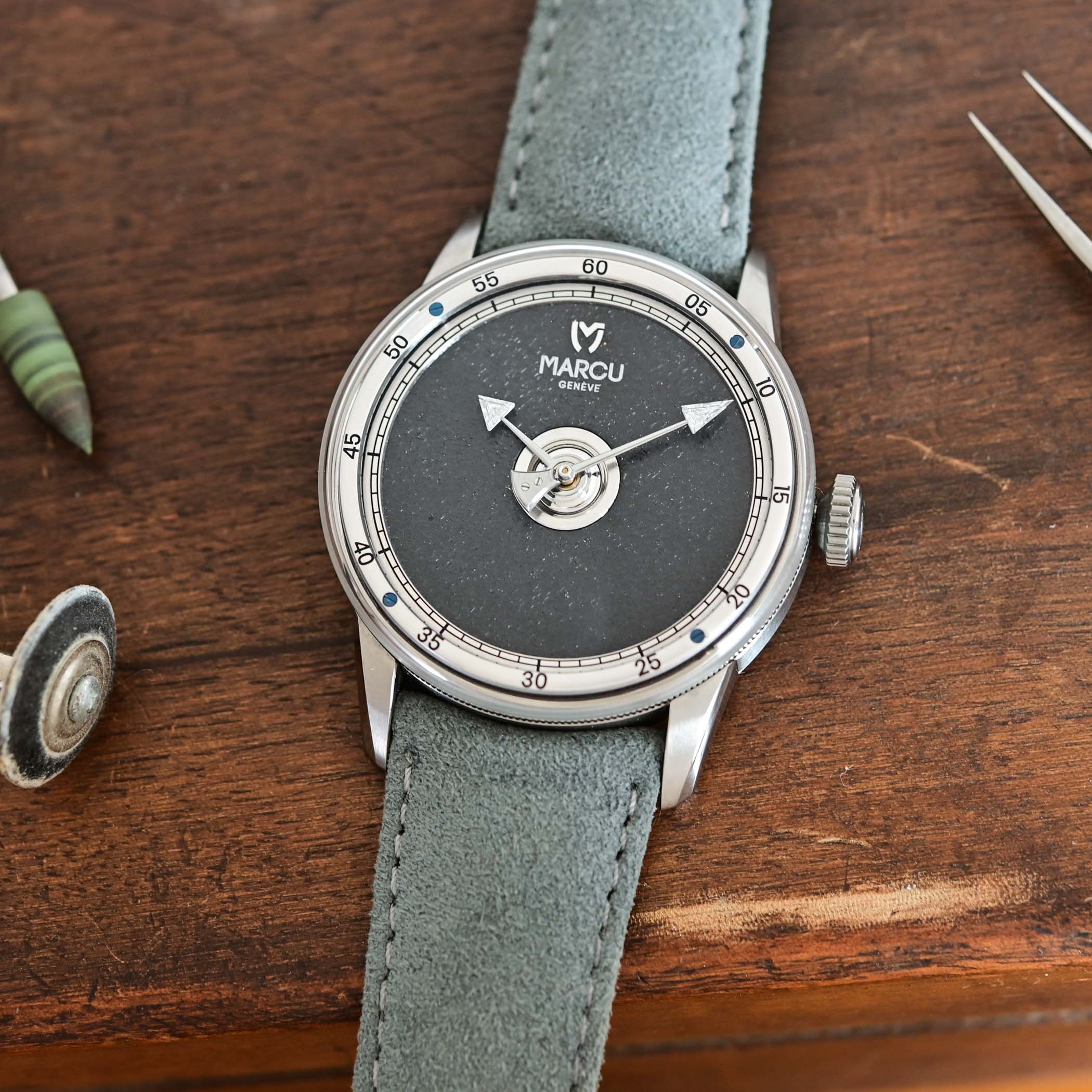 Top-down view of the Marcu Initial anthracite dial, the silvered five-minute chapter ring and the diamond-set hands over the pine-needle centre
